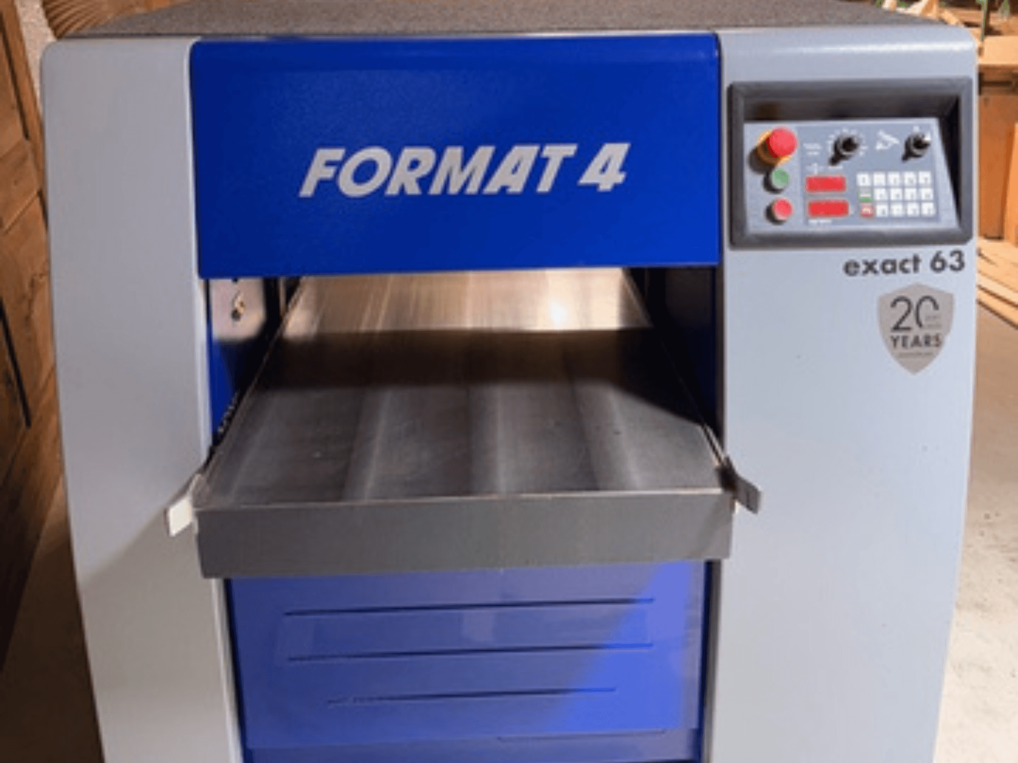 FORMAT 4 Exact 63 fűrészgép, elölnézet, fém adagolóasztallal, valamint gombokkal és kijelzőkkel ellátott kezelőpanellel.