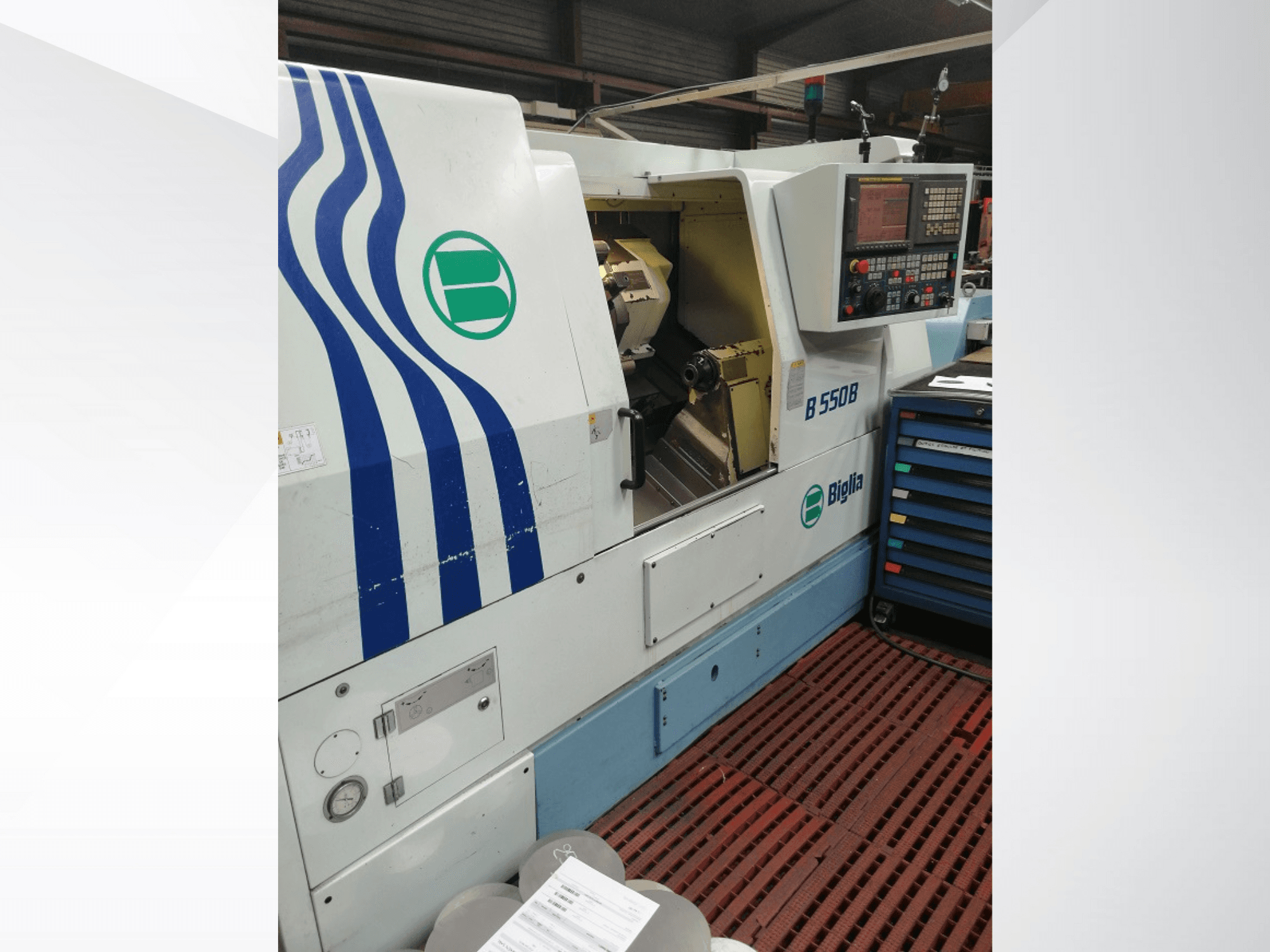 Biglia B 550 B CNC esztergagép szemből, a vezérlőpanel, a fémmegmunkálás területe és a színes szerszámtároló.