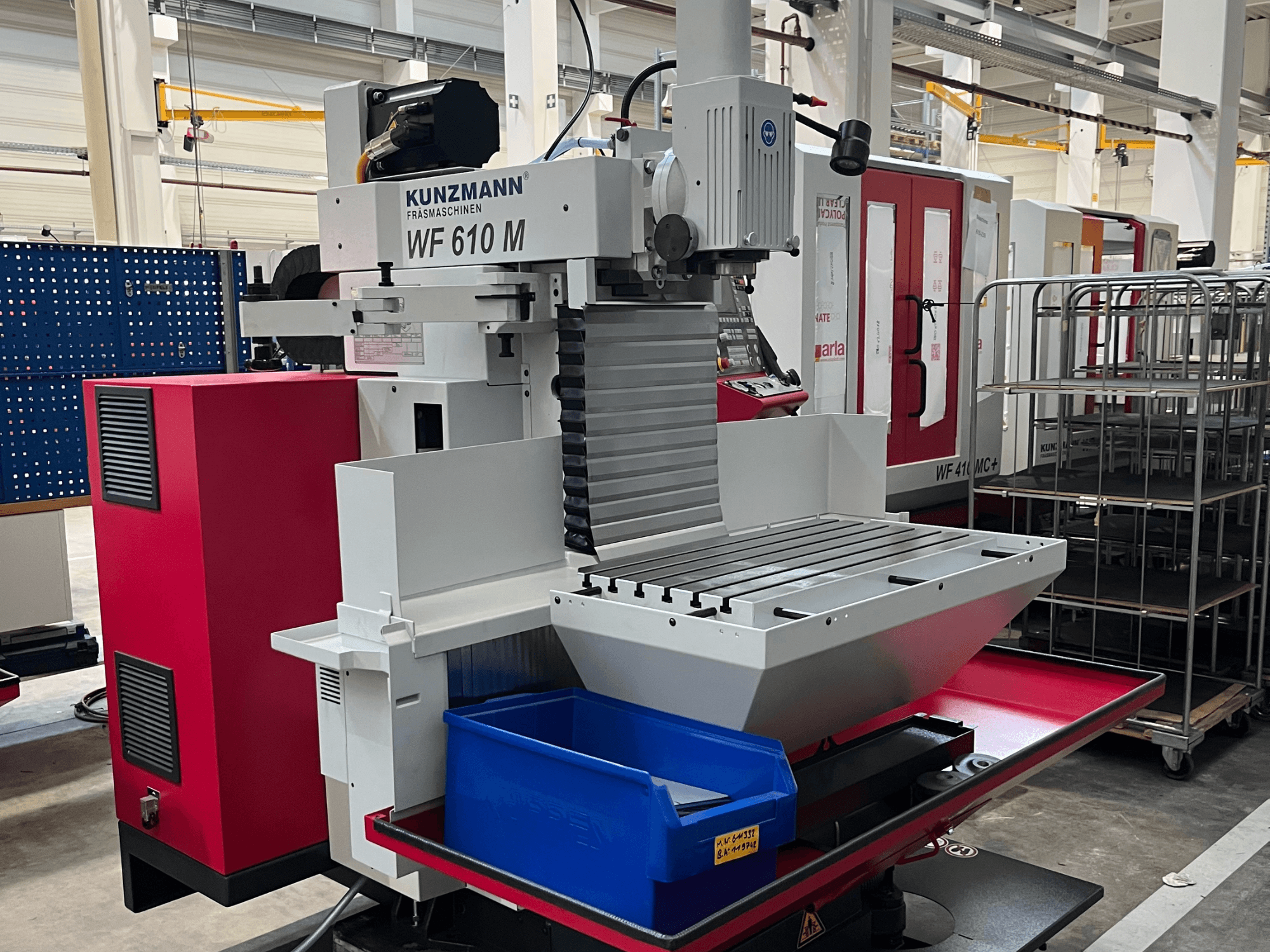 KUNZMANN WF 610 M univerzális megmunkáló központ, elölnézet, szerszámtartóval, vízszintes asztallal és kék tárolódobozzal.