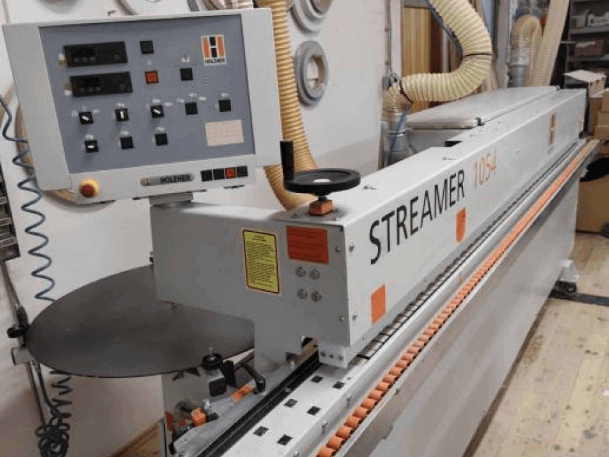 HOLZHER Streamer 1054 szegélycsiszoló, oldalnézet a vezérlőpanel és az adagolórendszer műhelyháttéren.