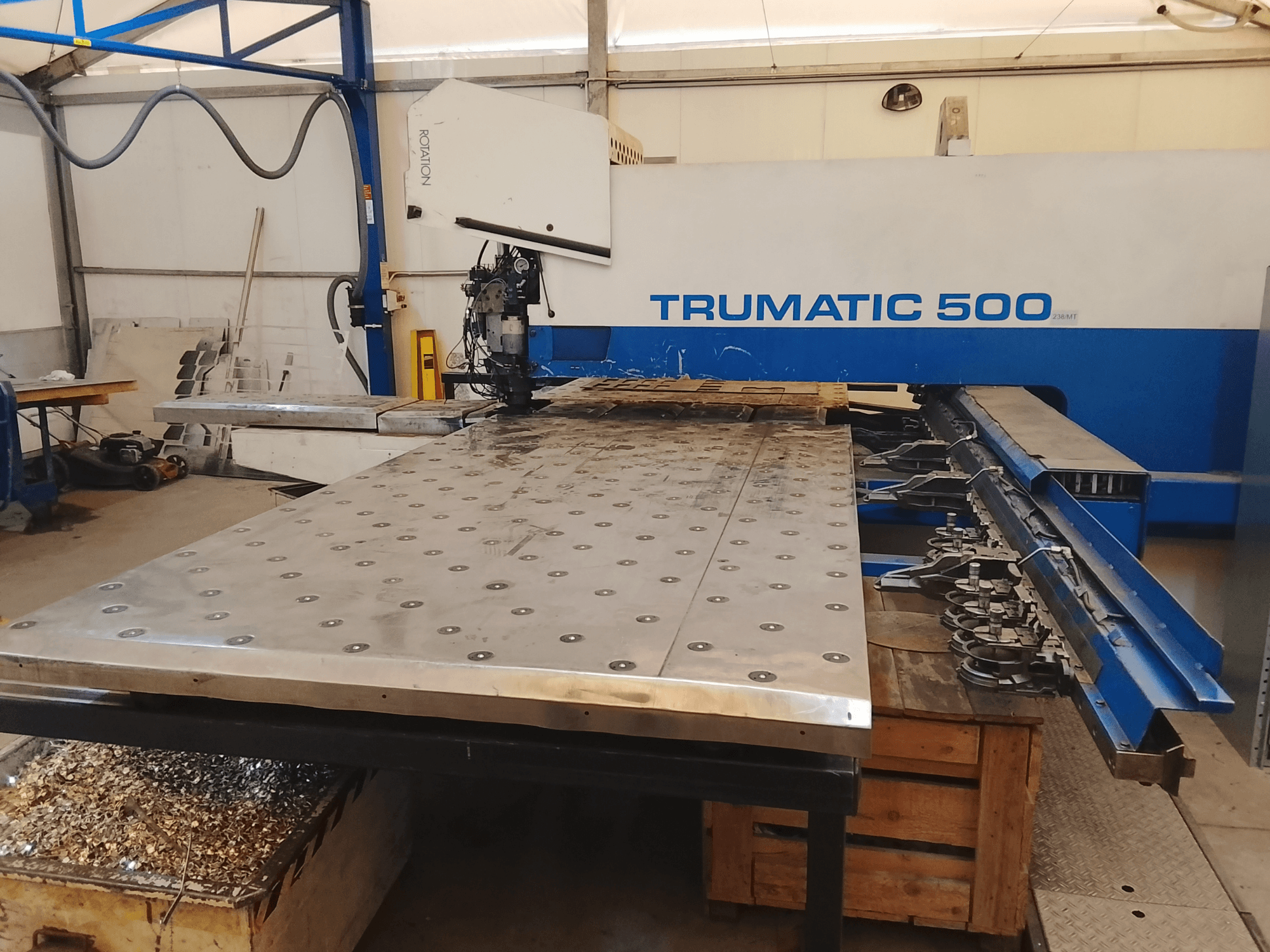 Trumatic 500 CNC-gép, felülnézet, nagy fémvágóasztal, alatta szerszámok és forgácsok.