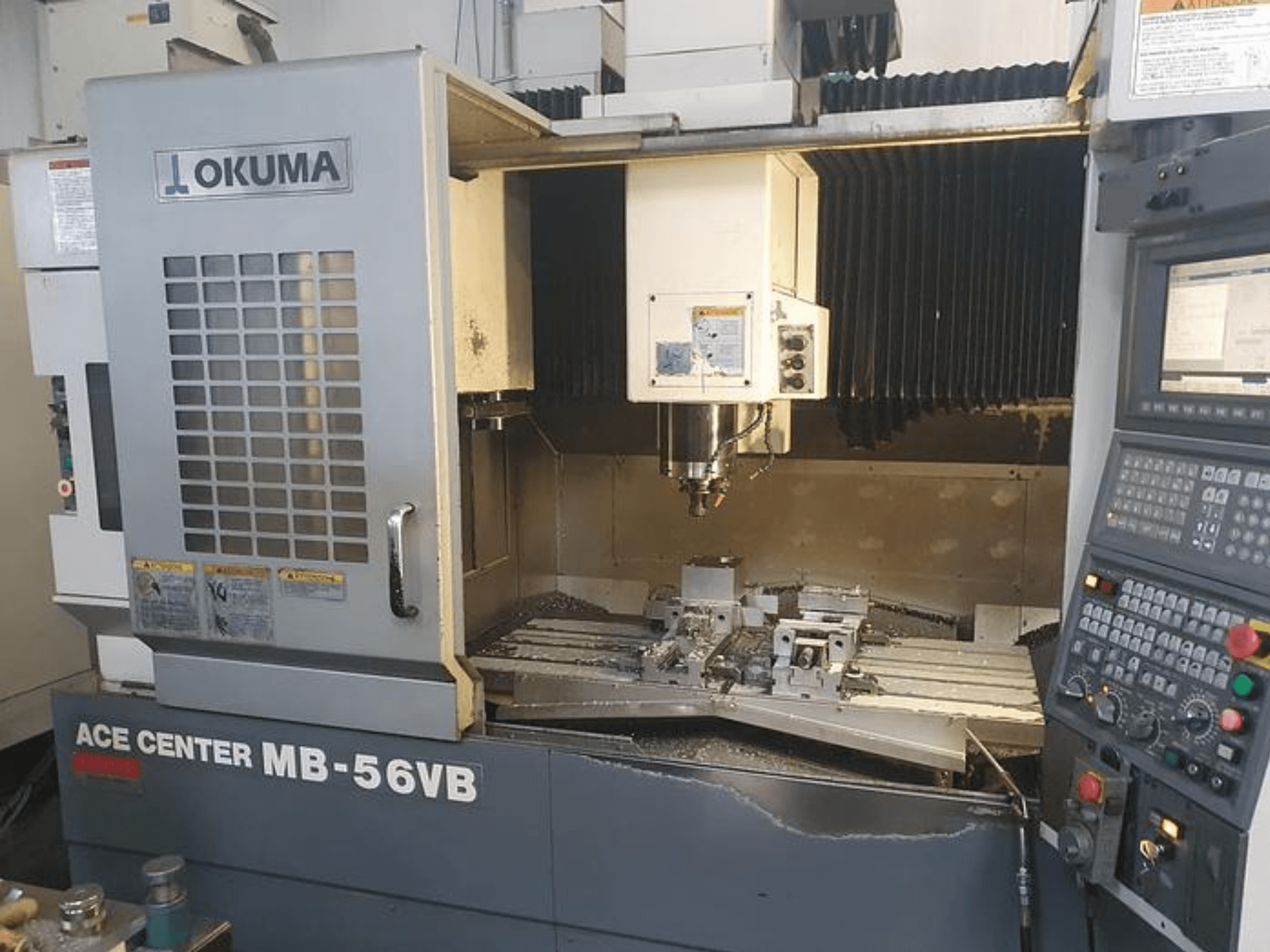 Okuma ACE CENTER MB-56VB CNC marógép elölnézetben, a vezérlőpanel és a megmunkálási terület bemutatásával.