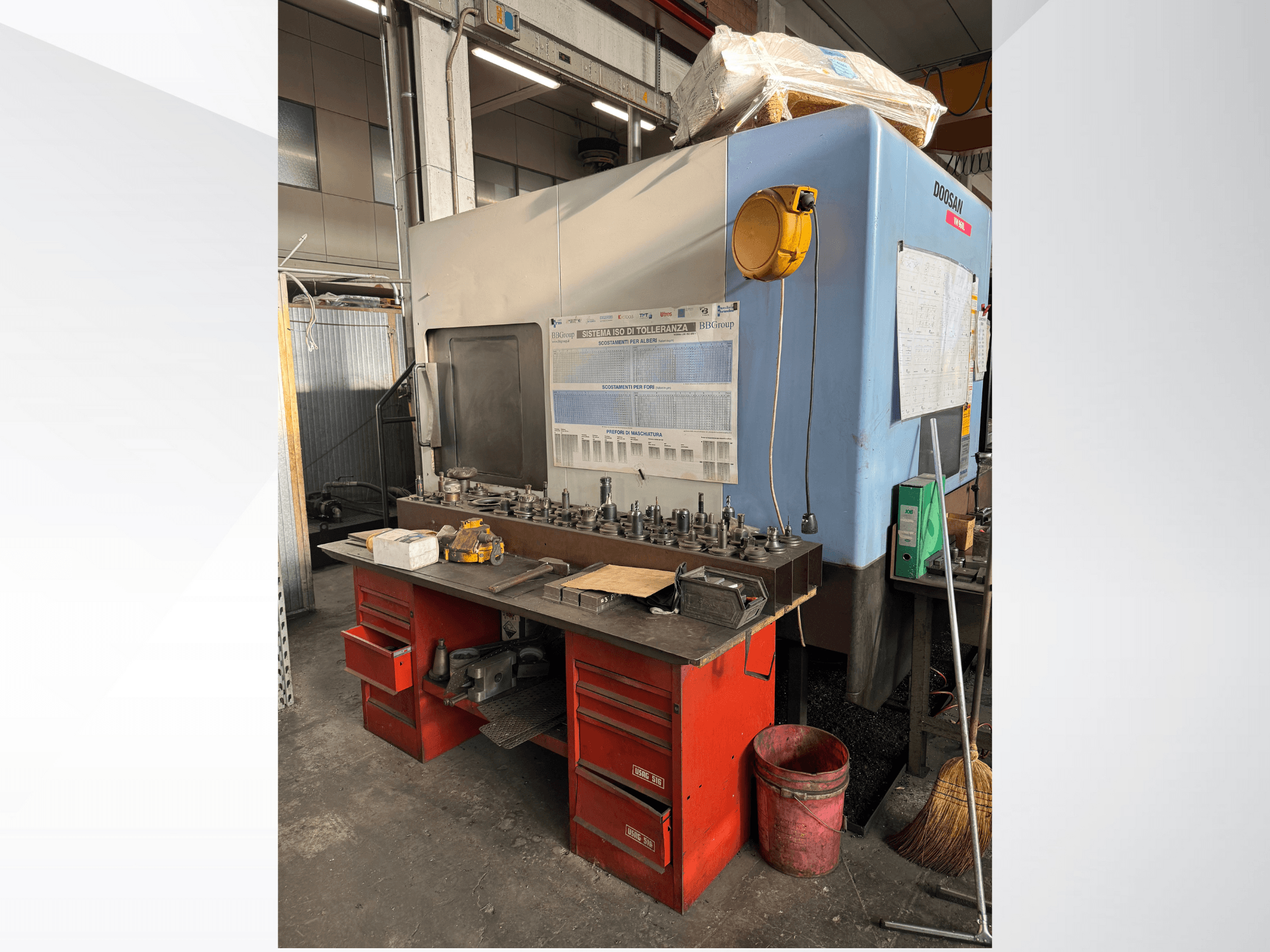 Doosan megmunkálóközpont piros munkapaddal és tárolóval, szerszámok és berendezések bemutatásával, szemből nézve.