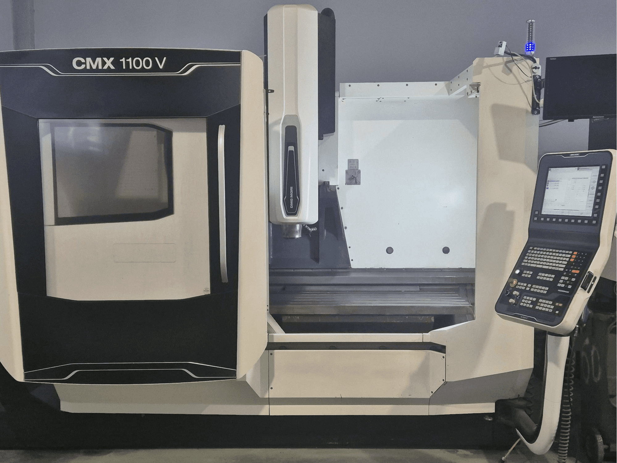 DMG MORI CMX 1100 V függőleges megmunkáló központ, elölnézet, amelyen látható a vezérlőpanel és a gépágy.