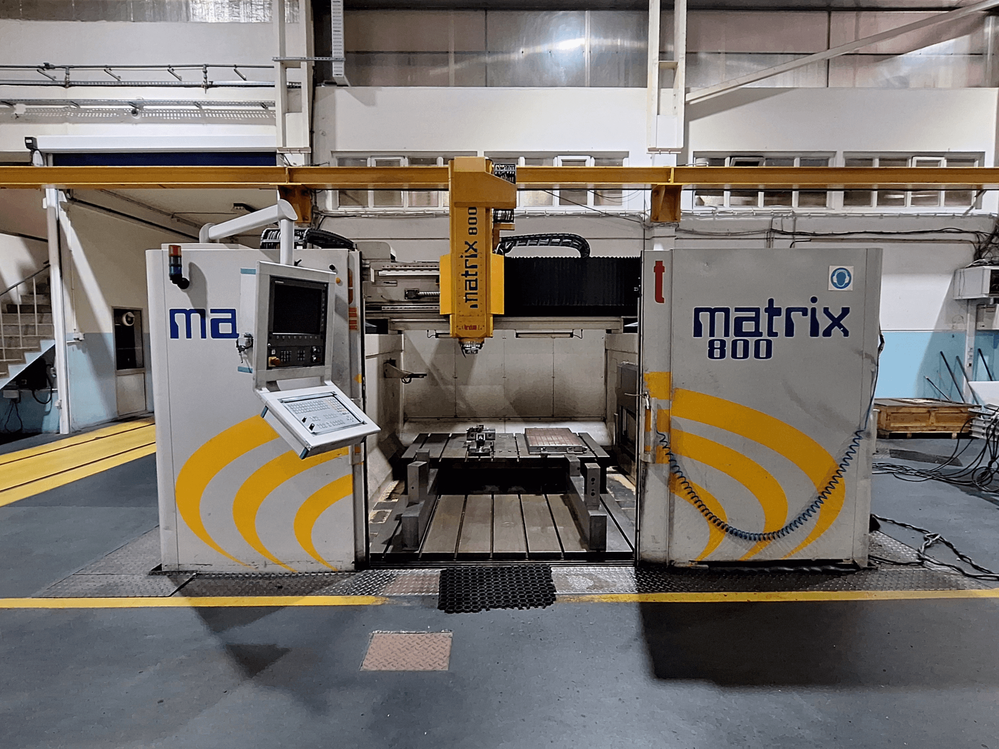 Breton Matrix WM 800 K25 portálmarógép egy műhelyben, a vezérlőpanel és a munkaasztal szemből nézve.