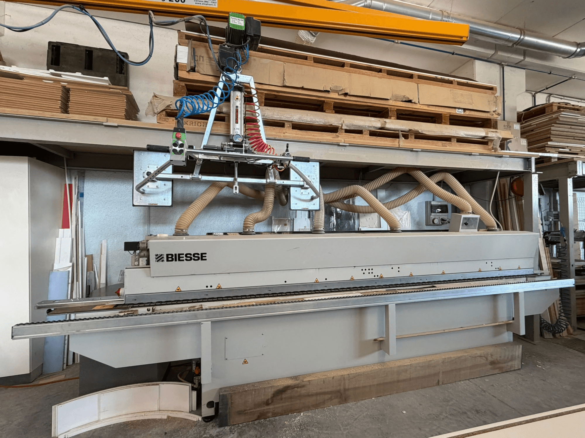 BIESSE AKRON 1330 élragasztó gép egy műhelyben, elölnézetben, a vezérlőpanellel és a porelszívó rendszerrel.