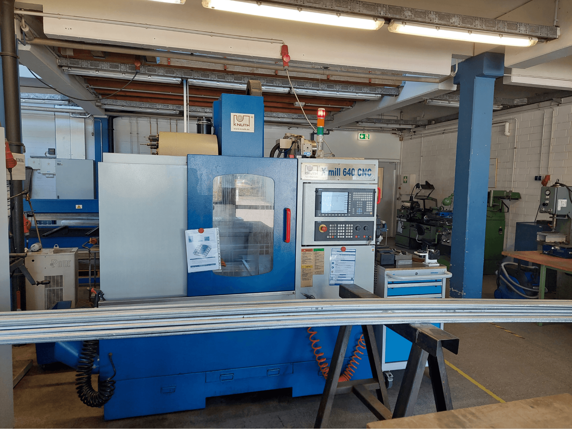 KNUTH X-Mill 640 függőleges megmunkáló központ, elölnézet, vezérlőpanellel és munkapulttal, műhelyi környezetben.
