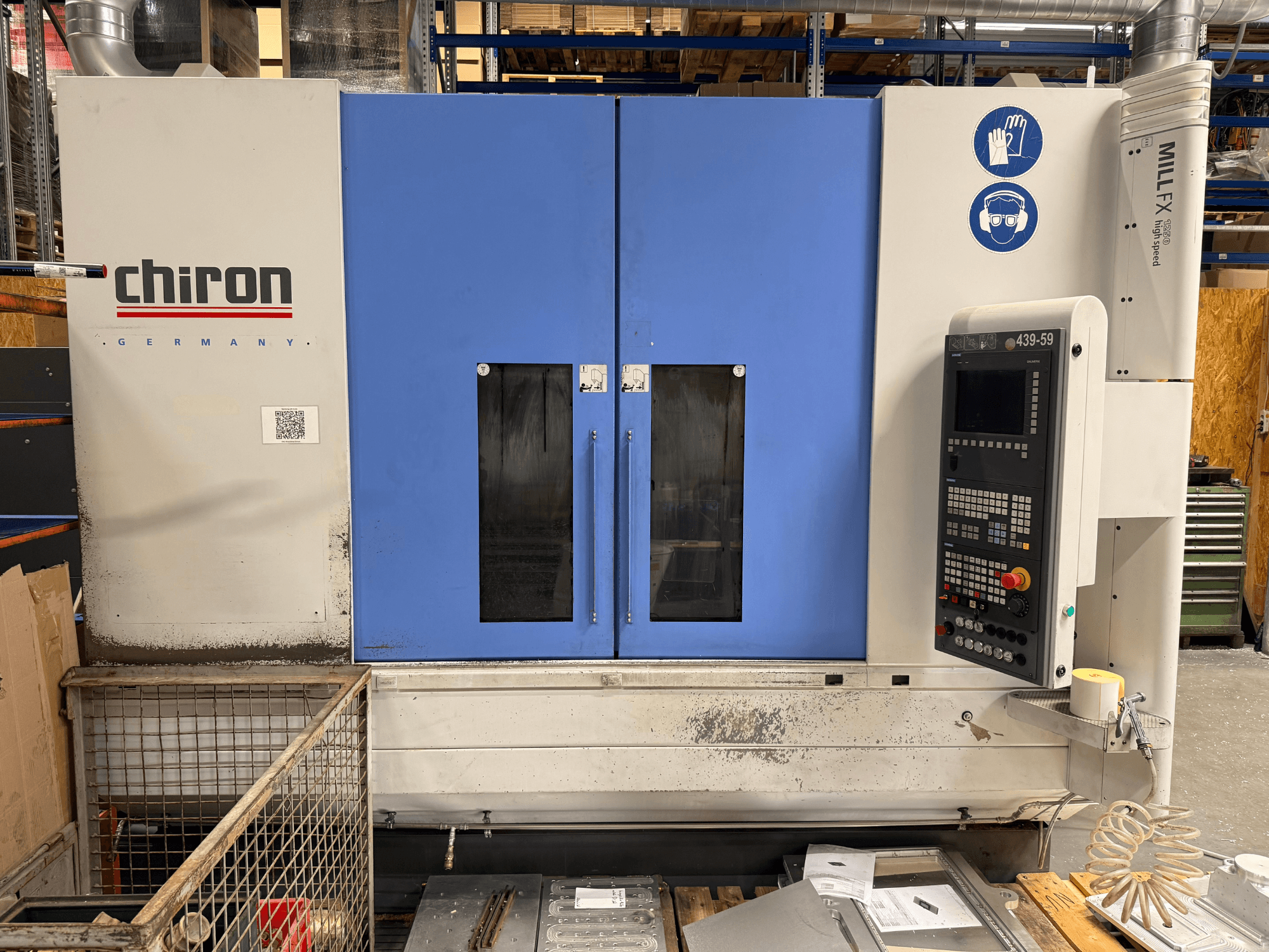 CHIRON MILL FX 1250 függőleges megmunkáló központ, elölnézet, a vezérlőpanellel és a biztonsági jelzésekkel, precíziós munkavégzésre készen.