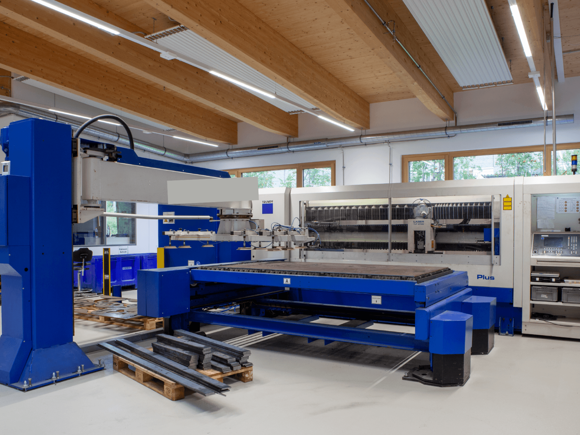 TRUMPF TRUMATIC L 2530 Plus CO₂-lézervágógép egy műhelyben, amely nagy vágóasztallal és ipari kialakítással rendelkezik.