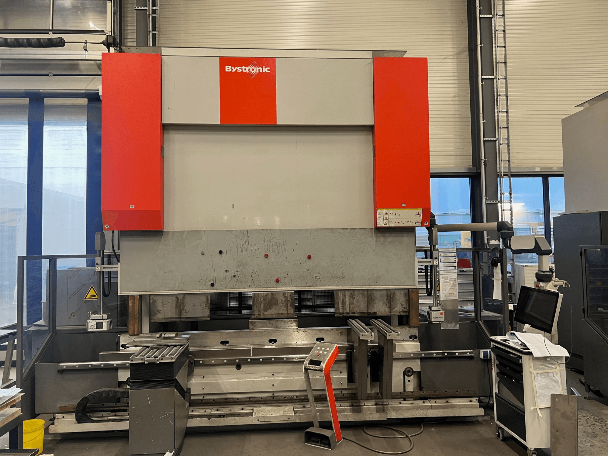 Bystronic lemezhajlító gép elölnézetben, elegáns kialakítással, vezérlőpanellel és biztonsági funkciókkal.