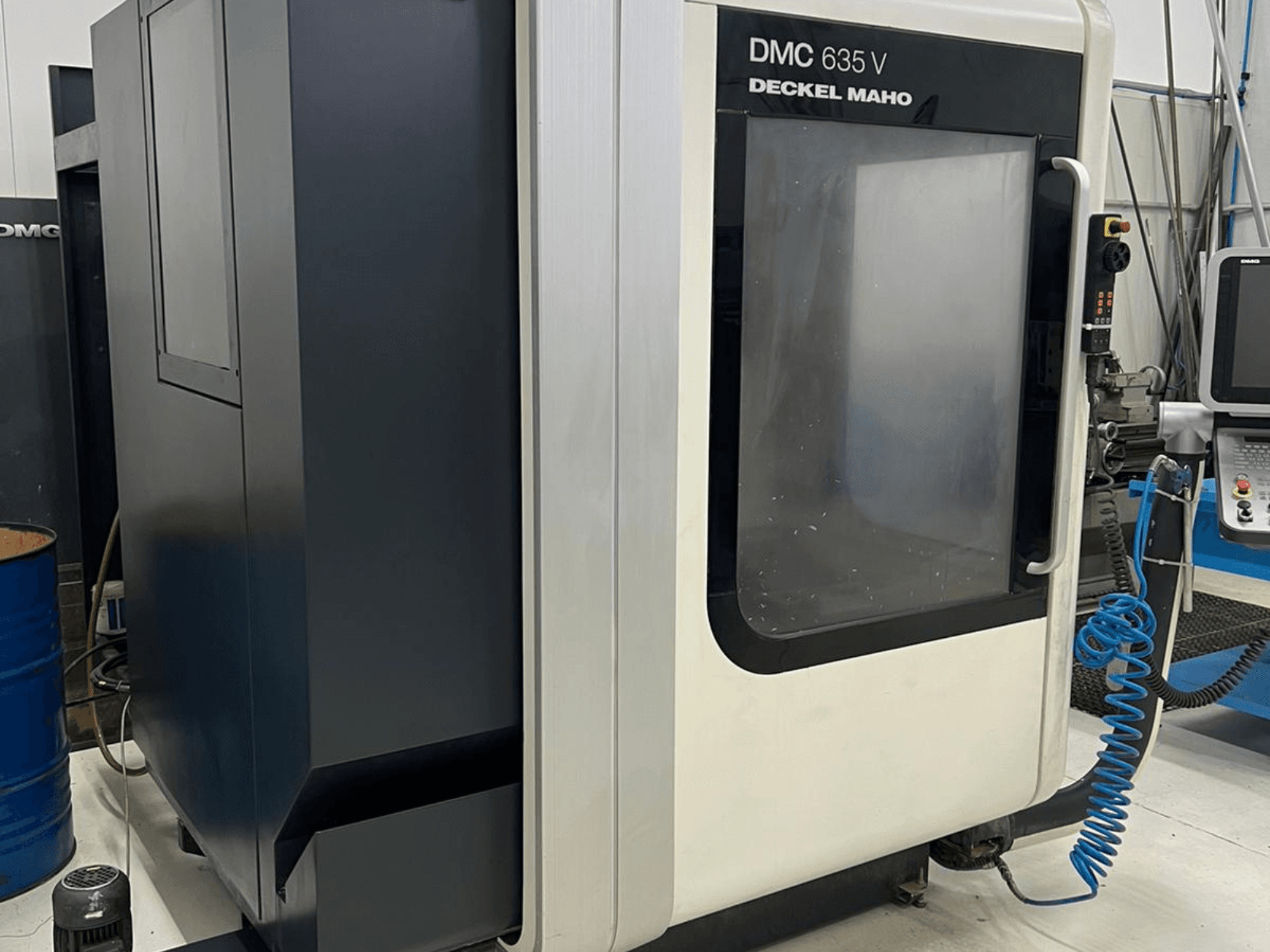 DMC 635 V marógép, Deckel Maho, oldalnézet a vezérlőpanel és a részben nyitott bejárati ajtó.