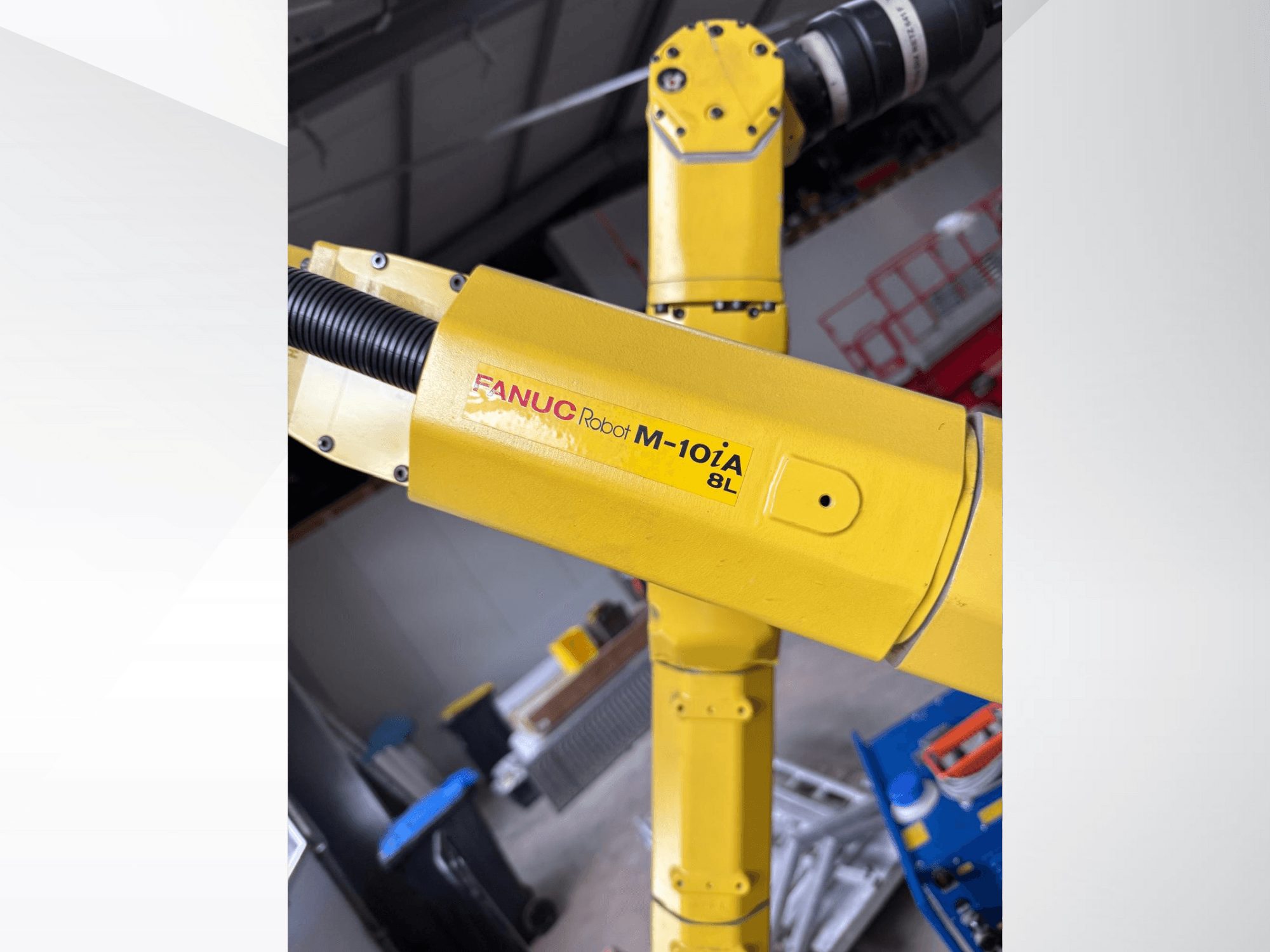 FANUC robot M-10iA 8L sárga színben, oldalnézetből, a karcsukló és a mechanikus alkatrészek ipari környezetben.