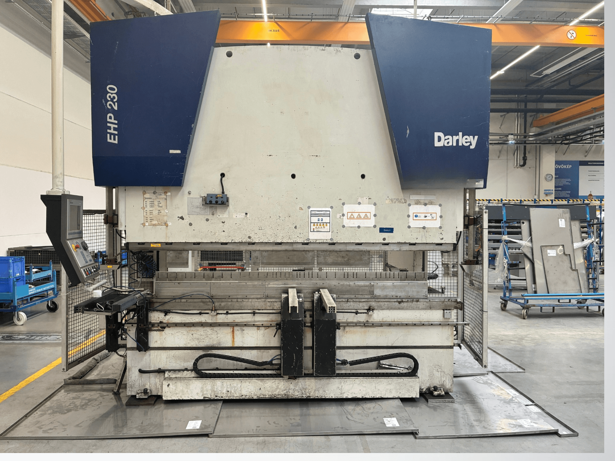 Darley EHP-LS 230.31/25 hidraulikus prés, elölnézetből, vezérlőpanel és fémlemezek a közelben. Ideális ipari alkalmazásokhoz.