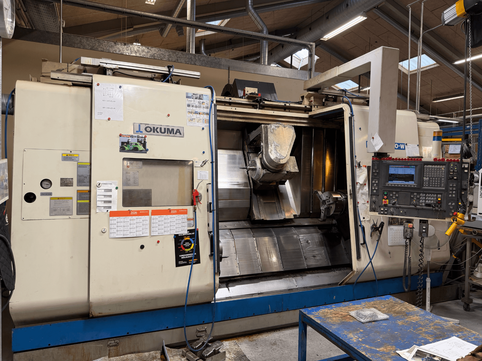 Okuma MacTurn350-W eszterga-marógép, elölnézet, amelyen látható a vezérlőpanel és a megmunkálási területhez való szabad hozzáférés.