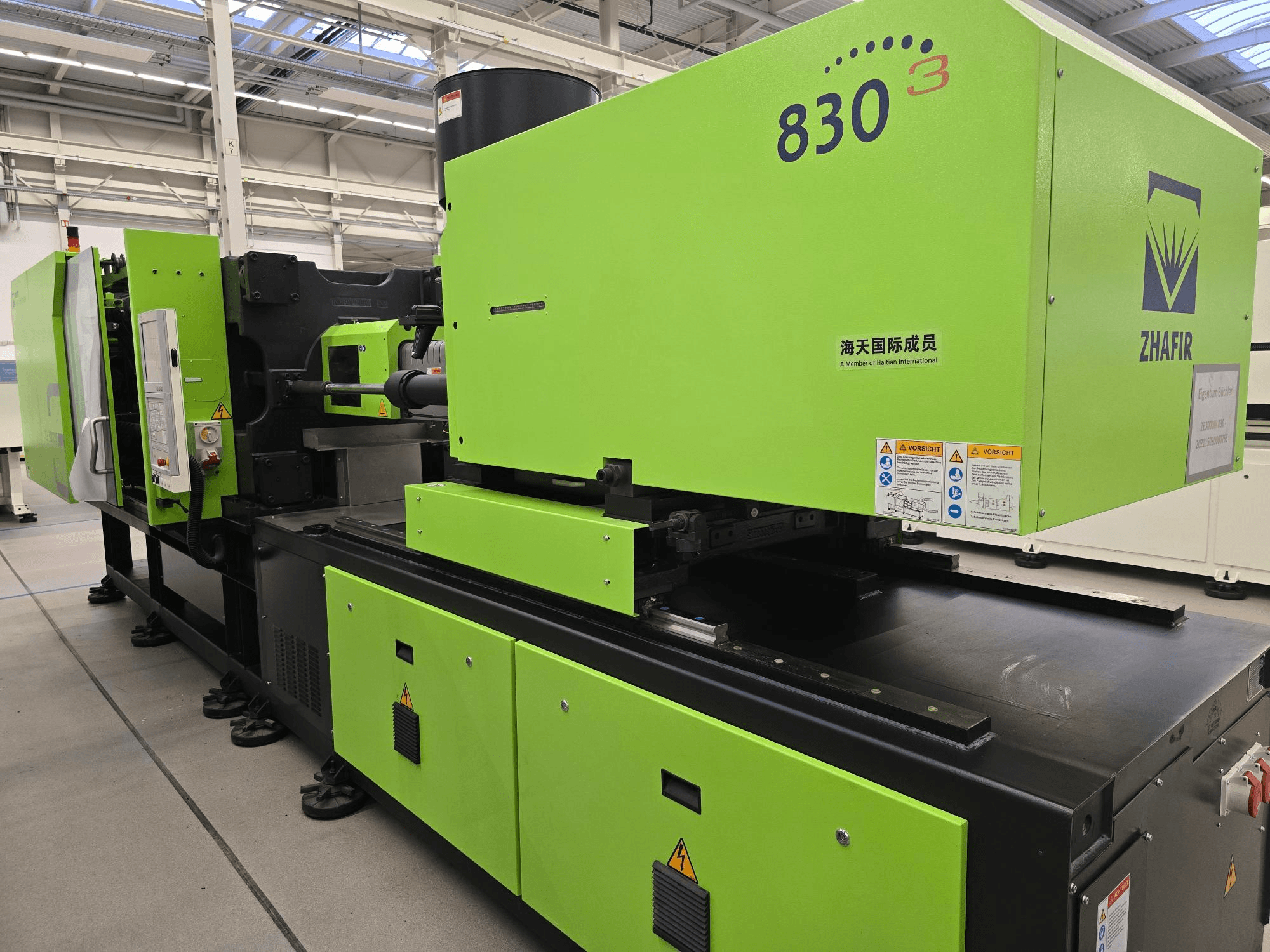 ZHAFIR ZERES III 3000/830/B5 elektromos fröccsöntőgép, oldalnézet, látható a fényes zöld burkolat és a vezérlőpanel.