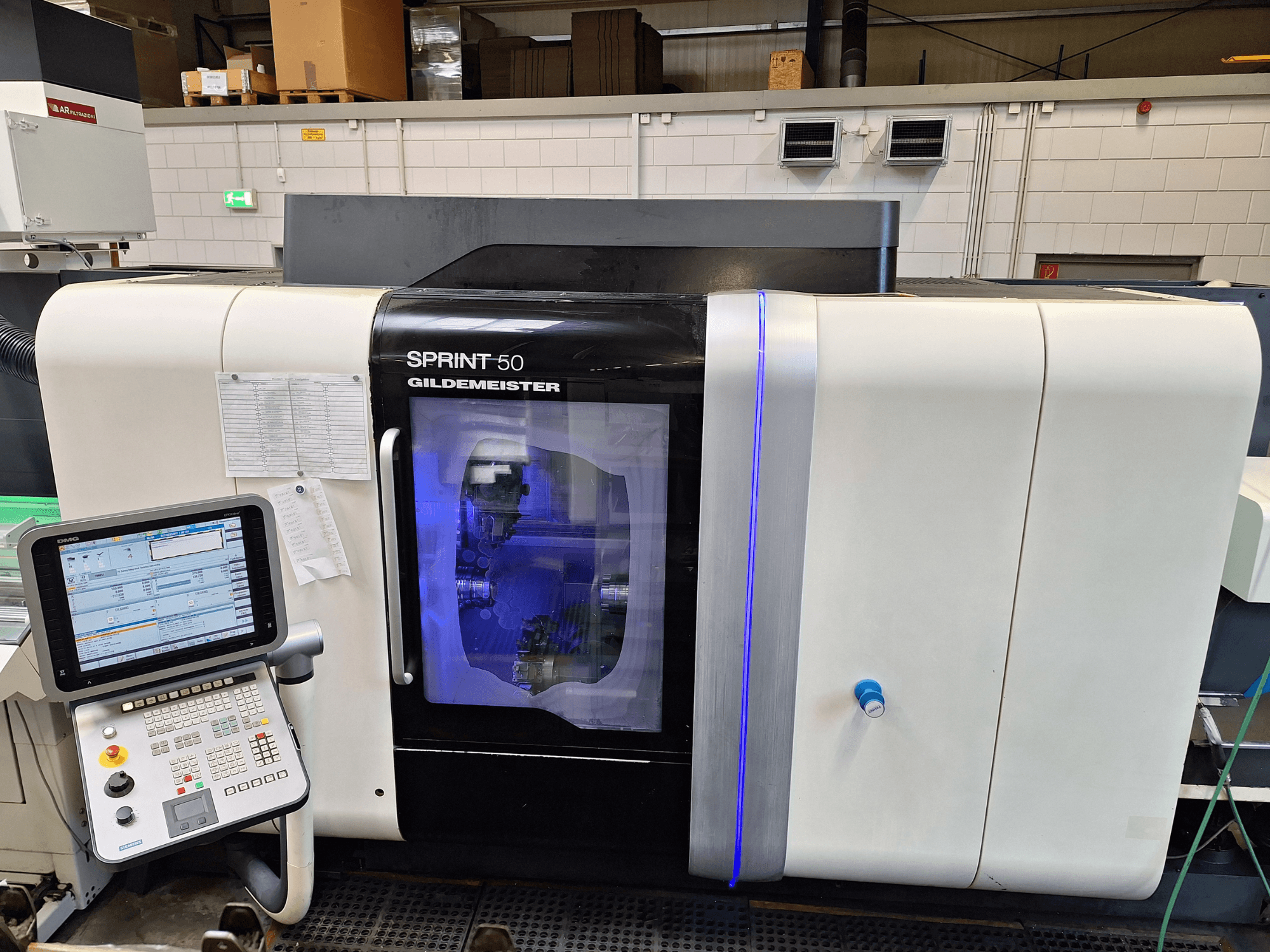 DMG Sprint 50 2T vízszintes esztergagép, elölnézetből, vezérlőpanel és a gépeket bemutató átlátszó burkolat.