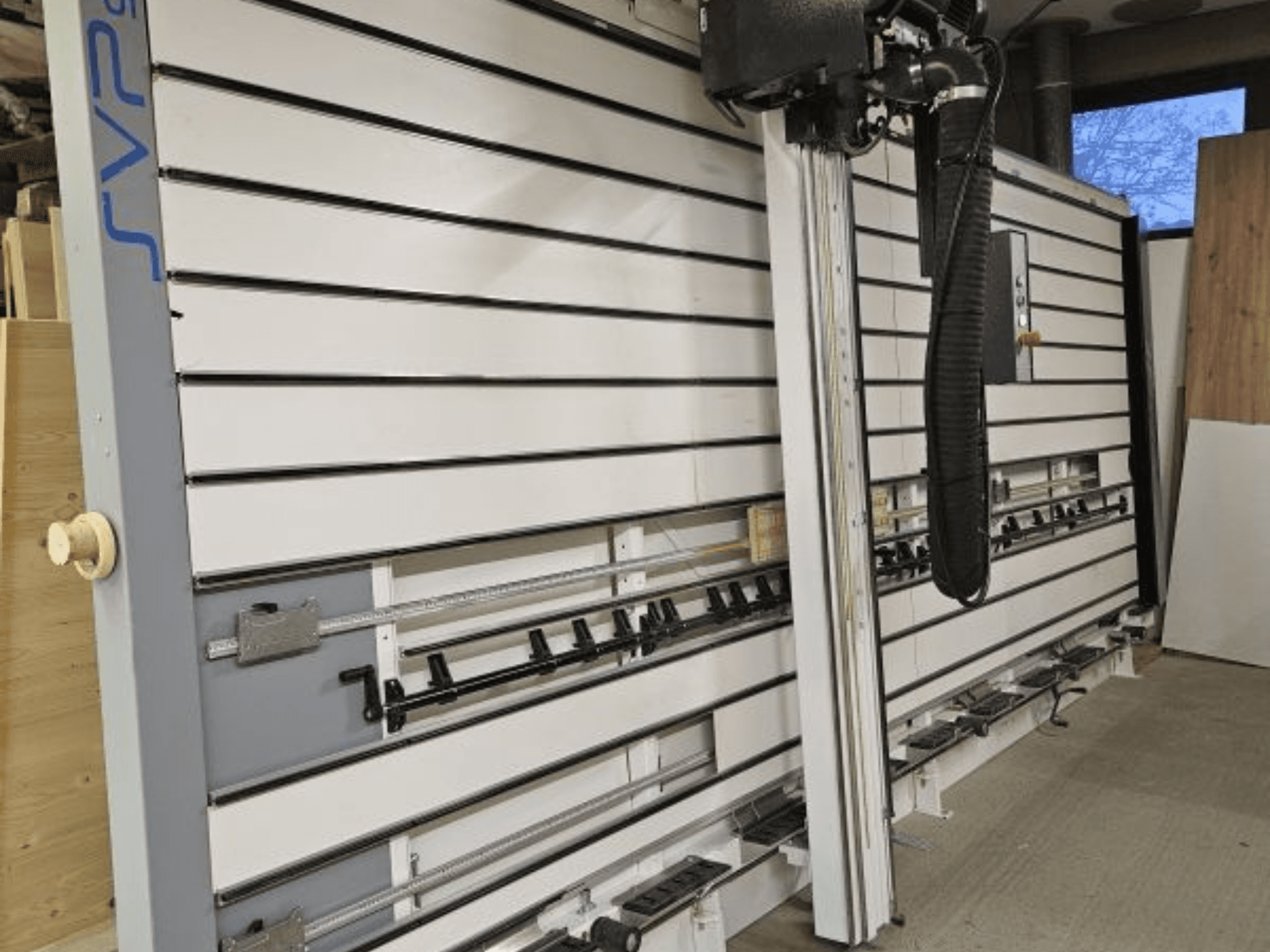 SVP csúszó lemezfűrész egy műhelyben, elölnézetben, állítható sínpályákkal és felső porelszívó rendszerrel.