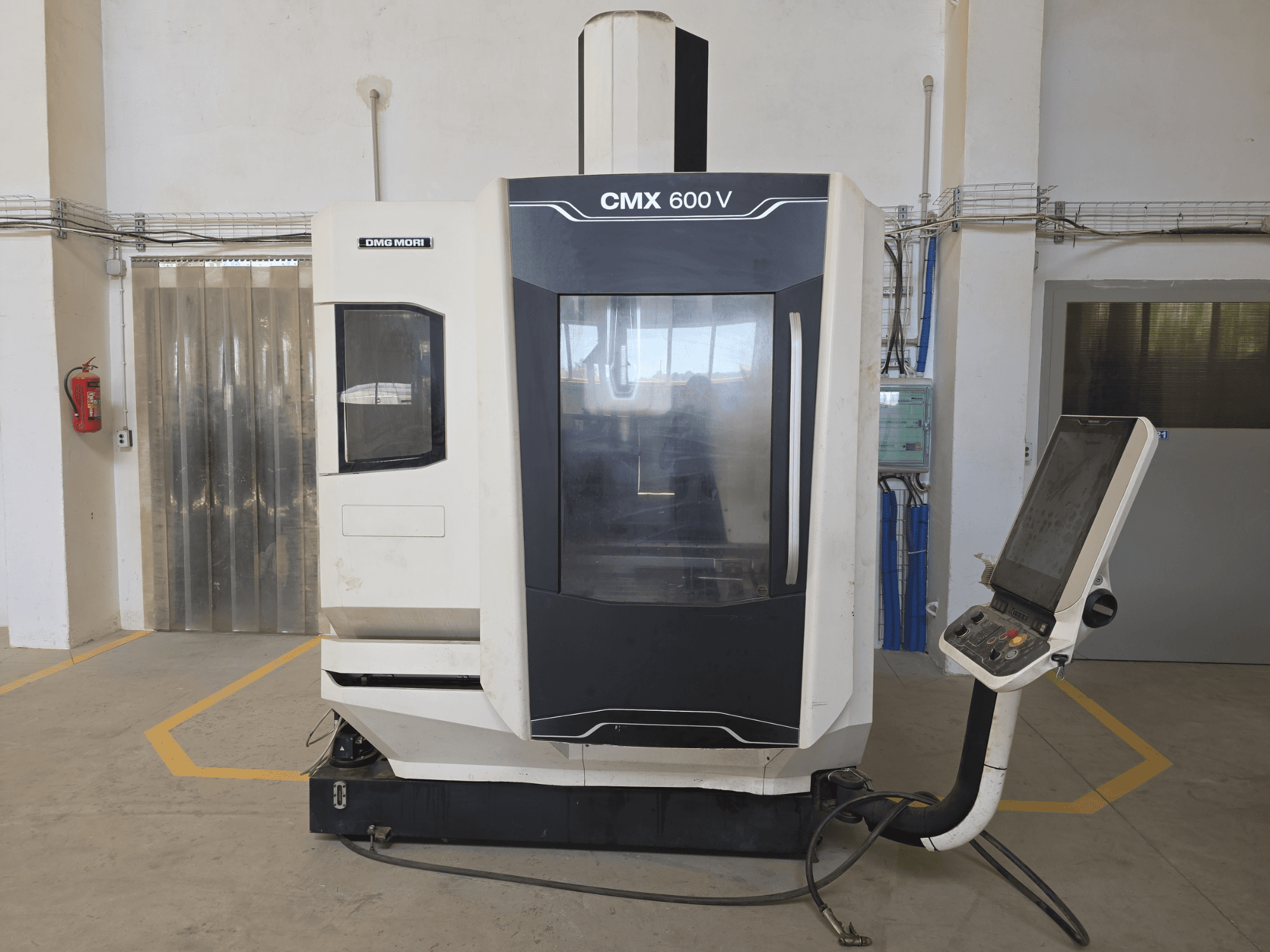 DMG MORI CMX 600 V függőleges megmunkálóközpont, előlnézet, a vezérlőpanel és a nagy átlátszó ablak bemutatása.