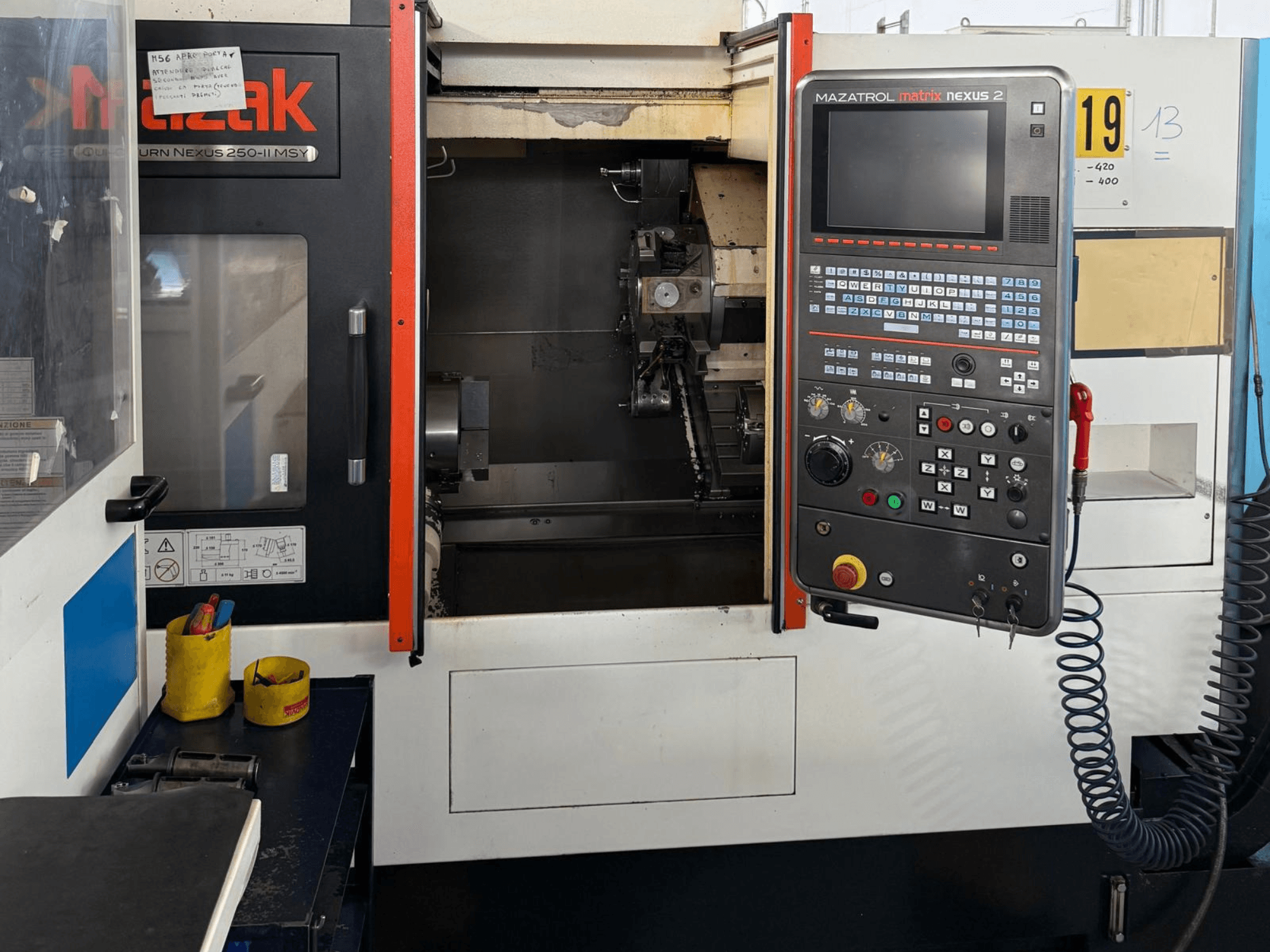 A Mazak QTN 250 II MSY vízszintes eszterga elölnézete, a MAZATROL Matrix Nexus 2 vezérlőpanellel és a gép alkatrészeivel.