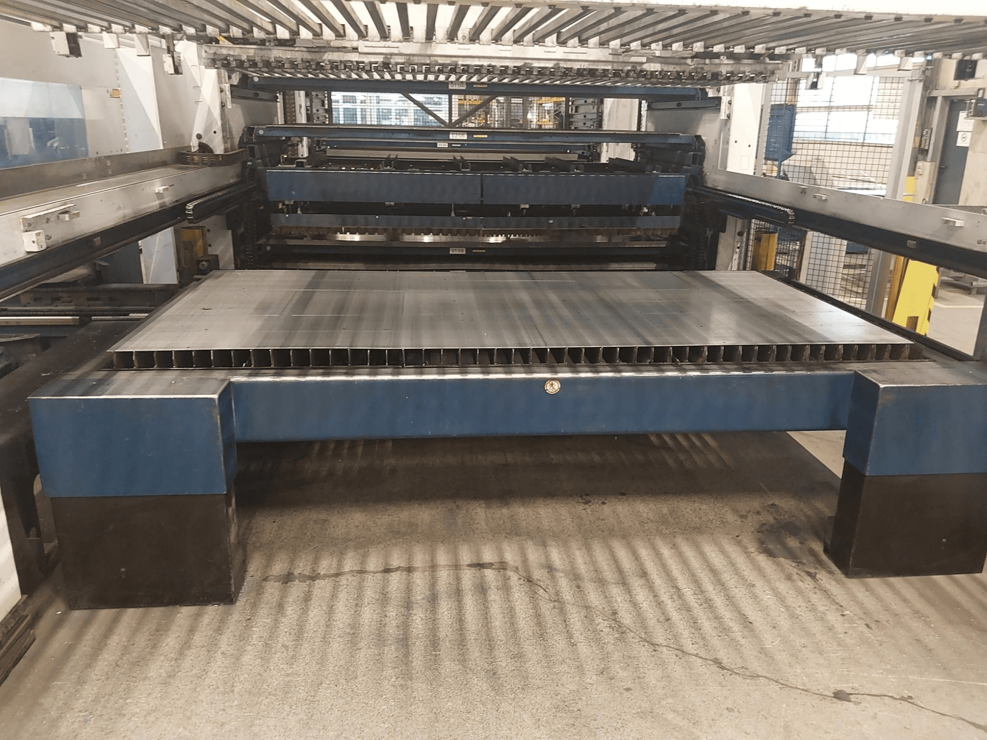 A TRUMPF TruLaser 3030 L20 CO2 lézervágógép előlnézetből, nagy vágóágy és tartószerkezet.