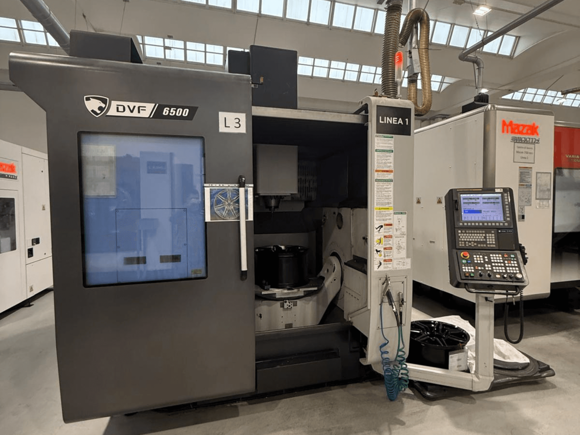 DVF 6500 CNC gép, előlnézet, a vezérlőpanel és a belső tér megjelenítése egy alkatrész rögzítővel.