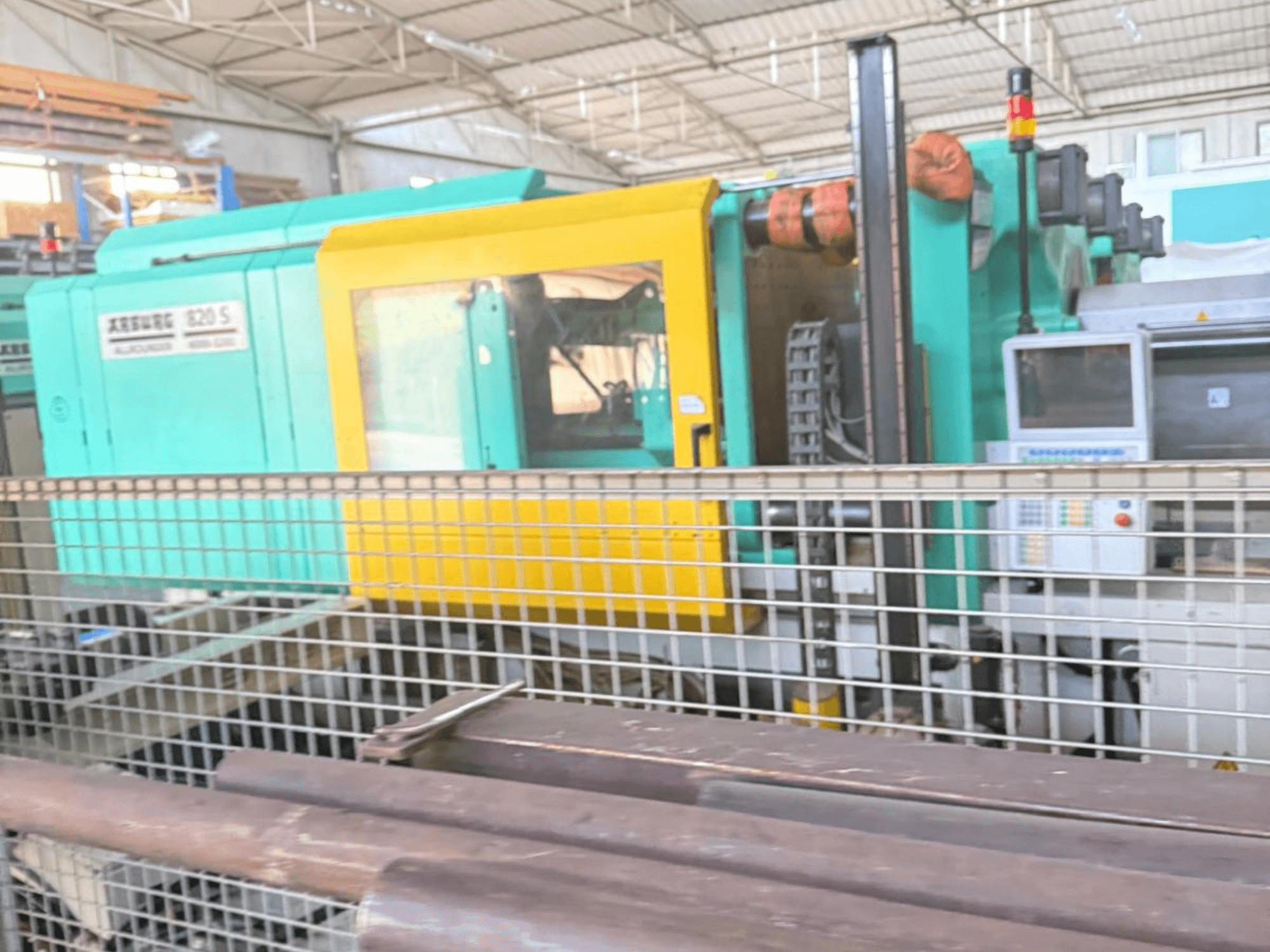 Arburg SELECTA 820 S 4000-3200 hidraulikus fröccsöntőgép, oldalnézet, a vezérlőpanel és az élénk sárga és teáskék dizájn.