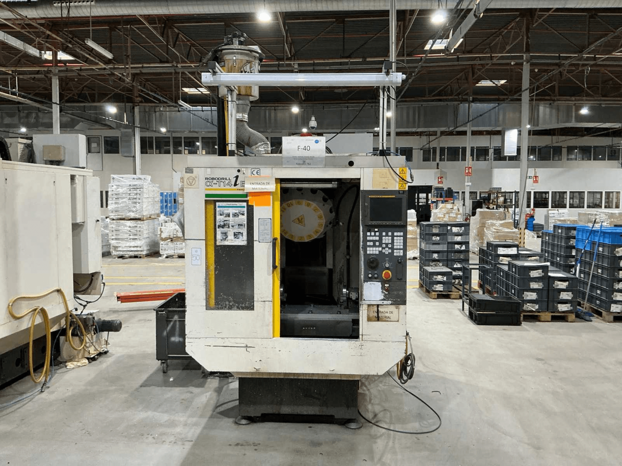 FANUC ROBODRILL α-T14iB függőleges megmunkálóközpont egy gyárban, elölnézetben a vezérlőpanel és a szerszámtartó.