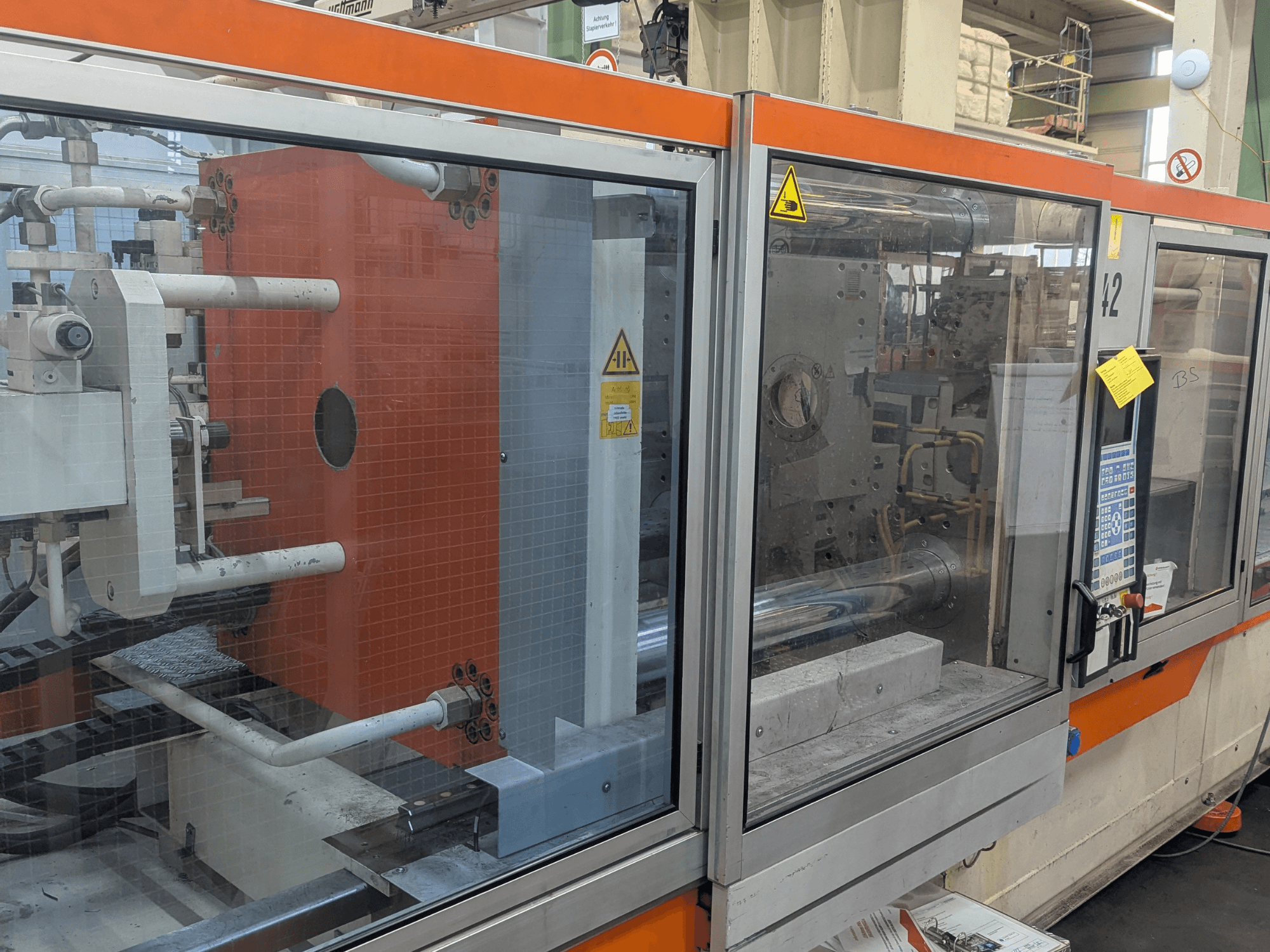 Egy DEMAG SYSTEC 80/420-310 hidraulikus fröccsöntőgép elülső nézete, látható vezérlőpanel és gépelemek.