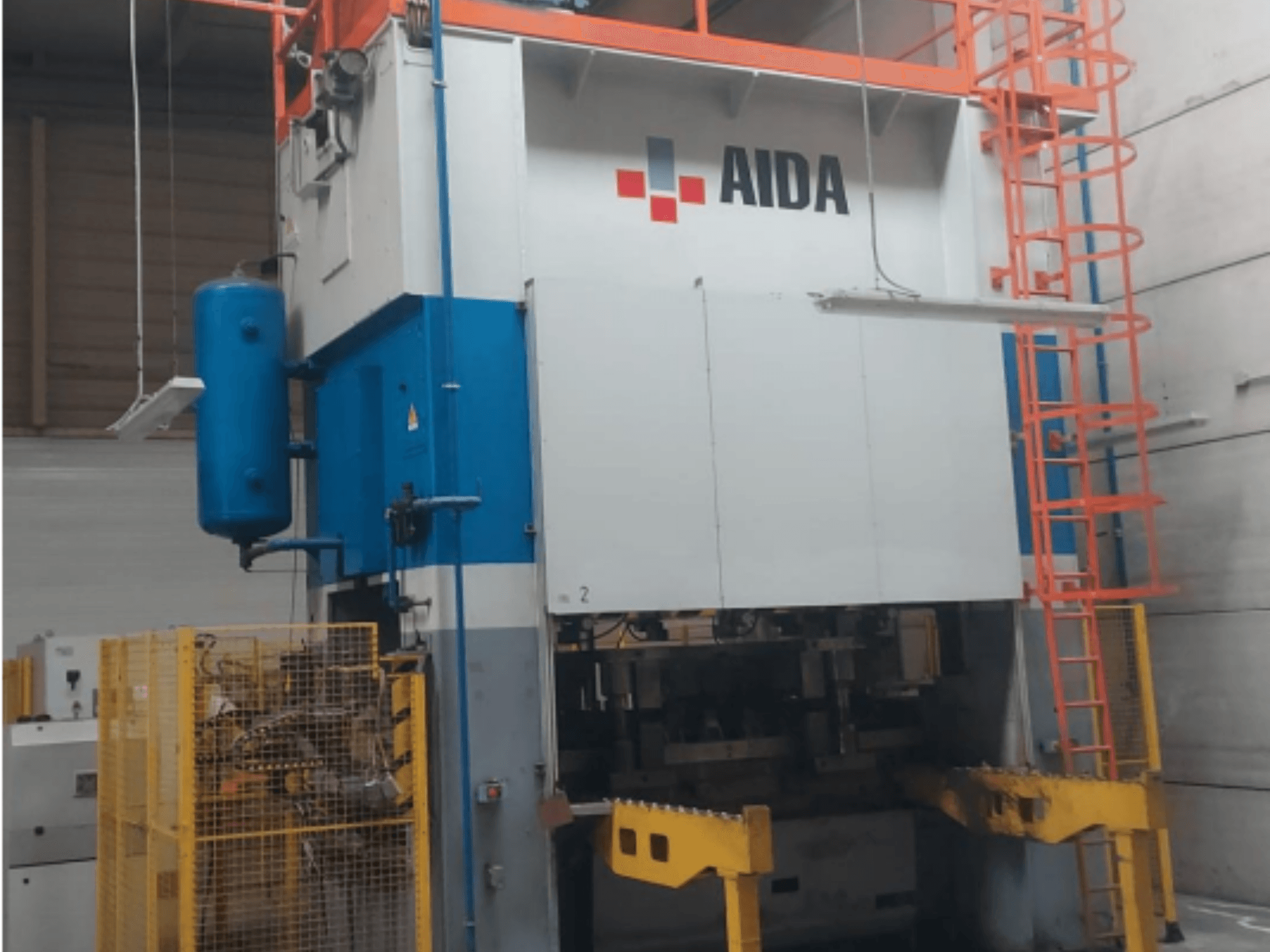 Mechanikus bélyegzőprés AIDA 315/2MR/LD/TE 3, elölnézetben, kék-fehér testtel, sárga talppal és biztonsági ketreccel.