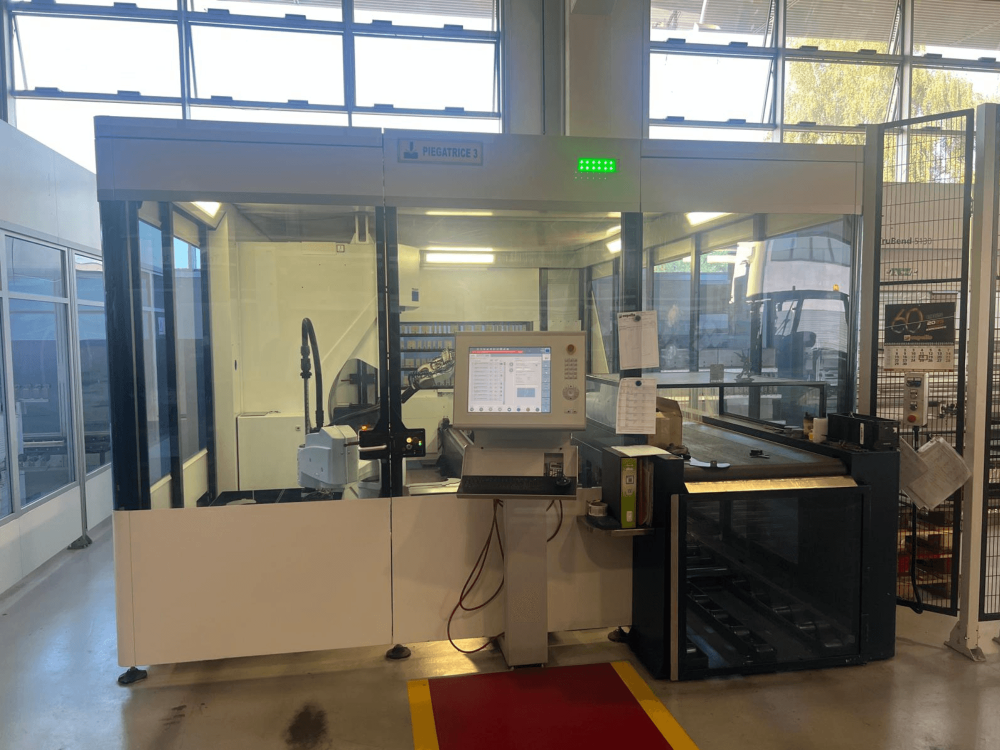 Ipari hajlítógép, Piegatrice 3 modell, elölnézet a kezelőpanellel és a robotkarral, jól megvilágított műhelyben.