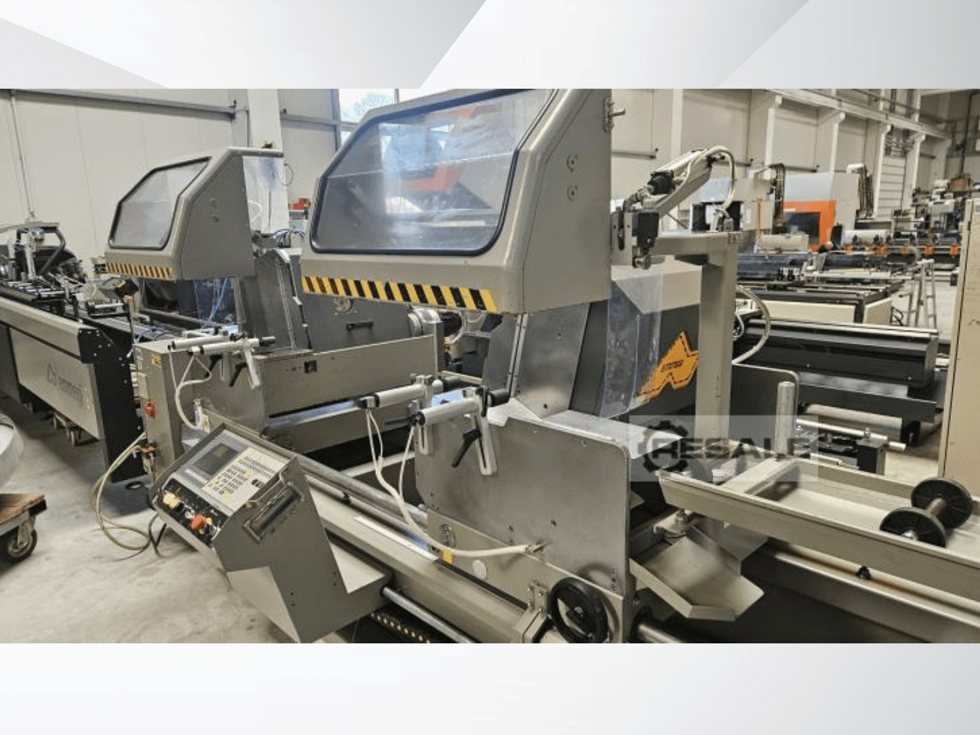 Kettős fűrészgépek gyári környezetben; elölnézetben a vezérlőpanel, az üvegburkolatok és a vágóelemek.