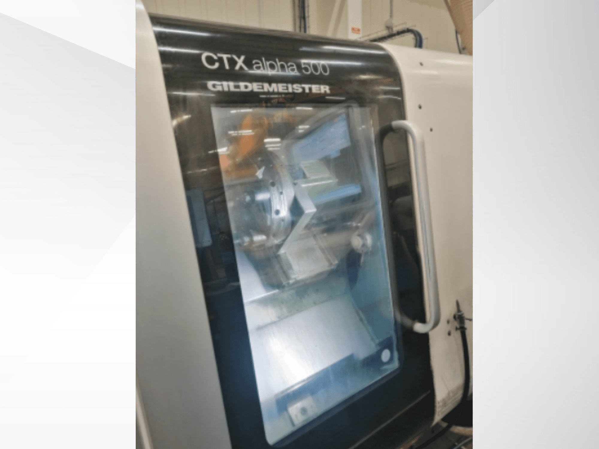 CTX alpha 500 Gildemeister CNC-gép, elölnézet, az orsó és a megmunkálási terület az üvegajtón keresztül.