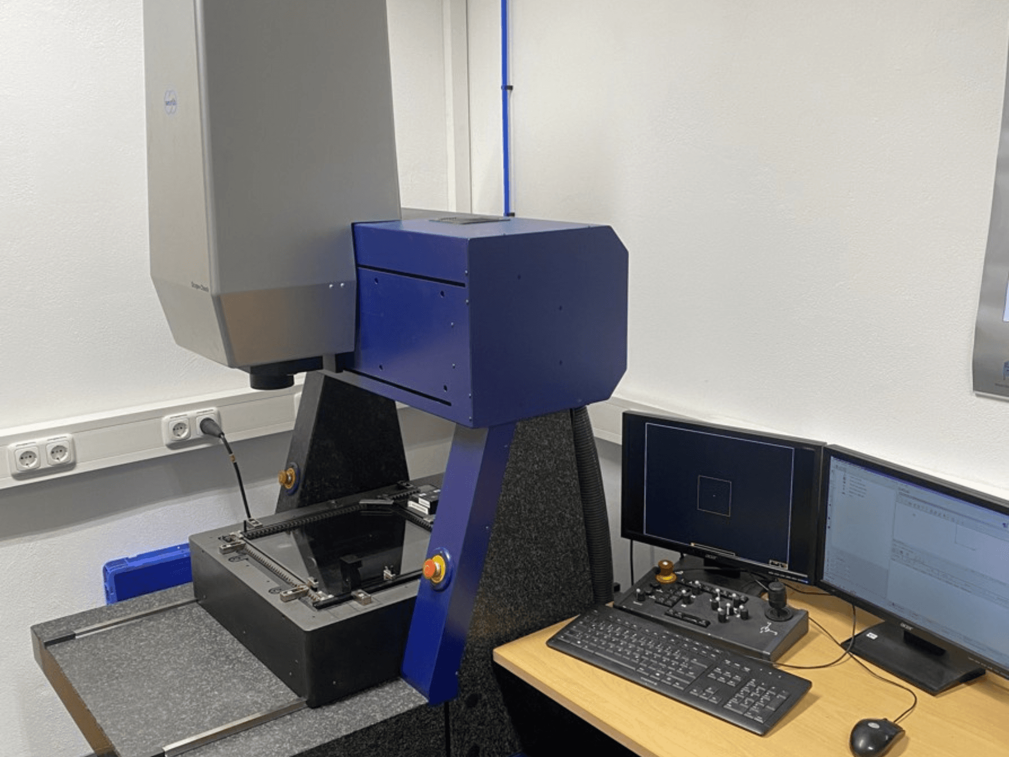 Werth Scope-Check 400 CMM egy laboratóriumban, a mérőfej és a képernyőkkel és billentyűzettel ellátott kezelőpanel.