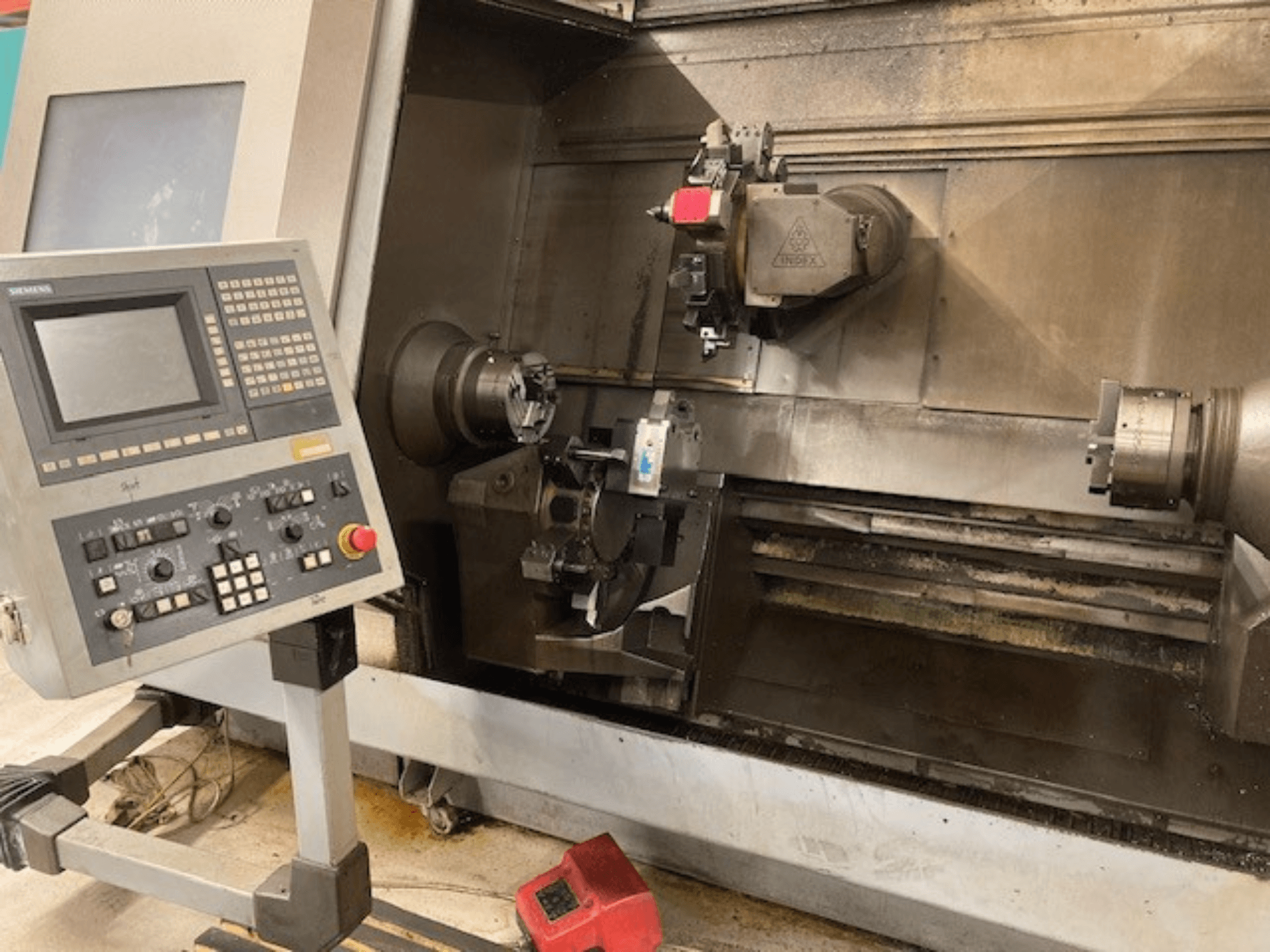 Vízszintes esztergagép Index G300 L YB vezérlőpanellel, látható tokmány és munkaterület, elölnézetből.