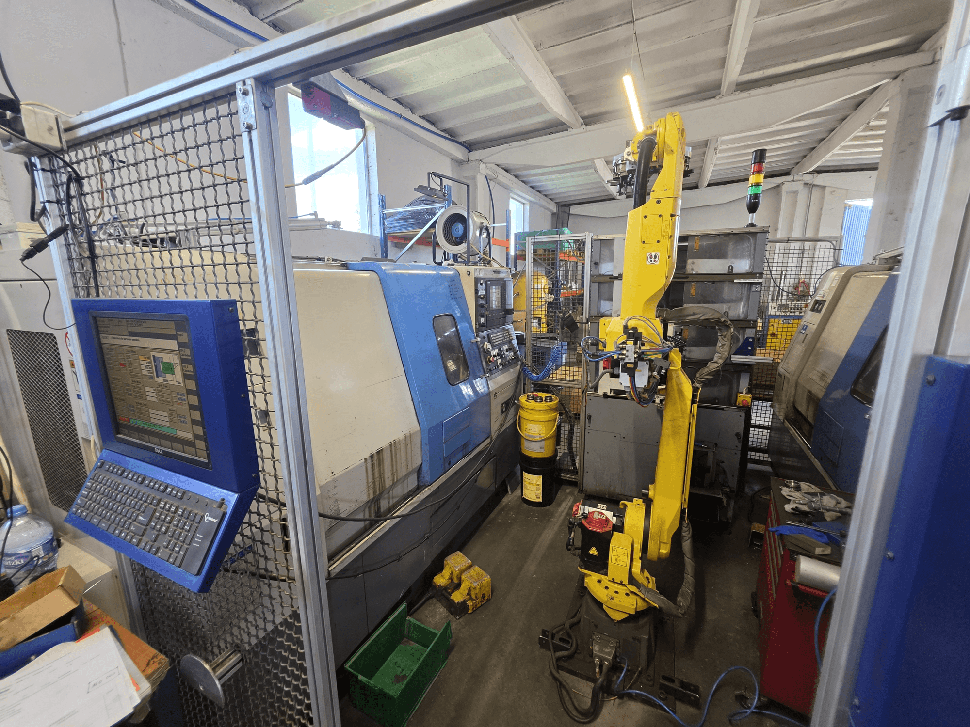 Hyundai HIT-200C vízszintes eszterga FANUC M-20iA robottal, elölnézet, amelyen látható a vezérlőfelület és a gép felépítése.