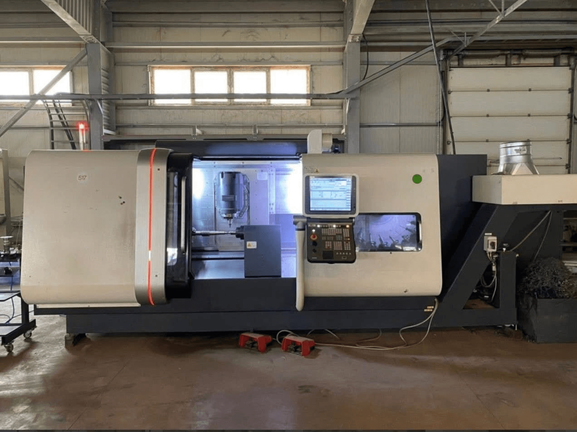 DMG MORI Beta 1250 TC esztergapadozó központ, elölnézetben a vezérlőpanel, a megvilágított munkaterület és a vágószerszámok láthatóak.