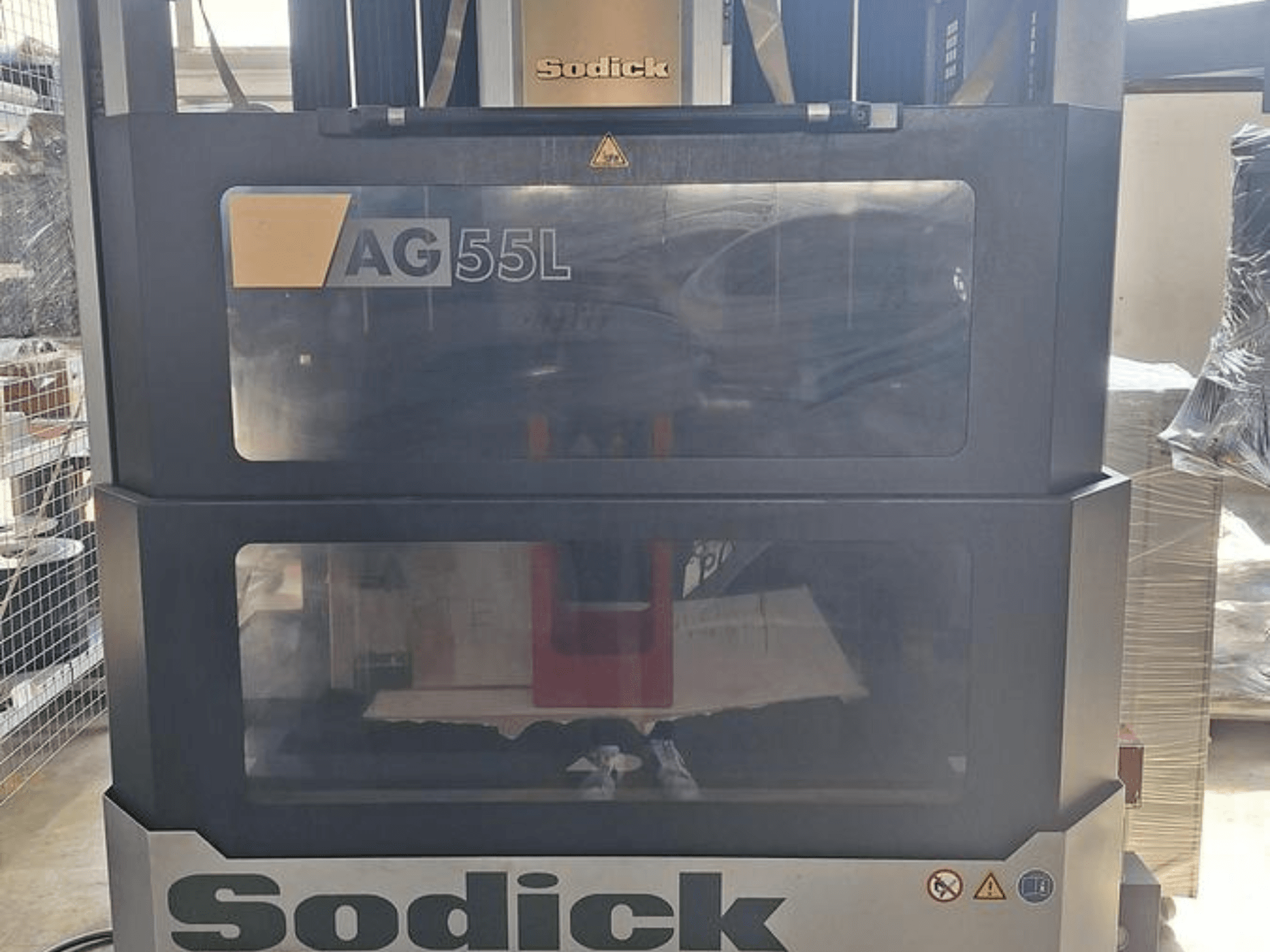 Sodick AG 55L süllyesztéses szerszámsüllyesztő gép, előlnézet, a kezelőszervek átlátszó panelen keresztül láthatóak, a belső munkaterületet mutatja.