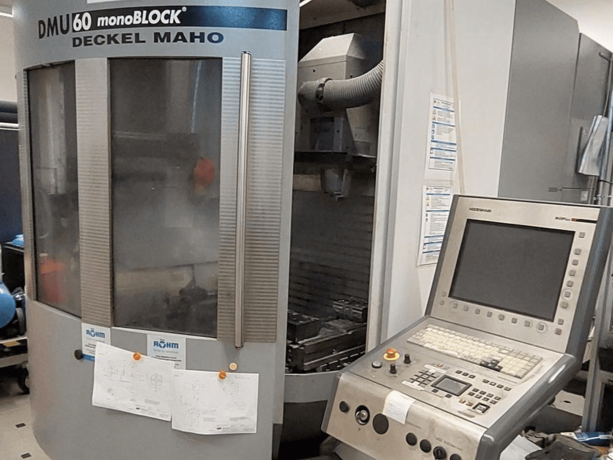 DMU 60 monoBLOCK a Deckel Maho cégtől, egy CNC marógép előlapja a vezérlőpanellel és a műszaki rajzokkal együtt.