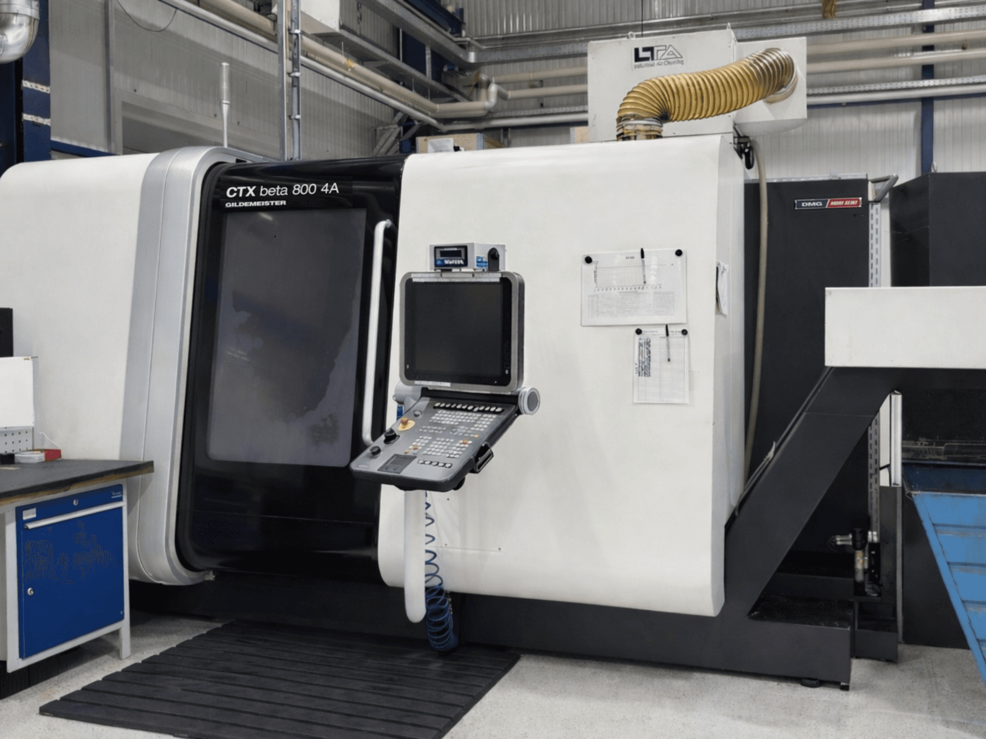 DMG CTX beta 800 4A többorsós eszterga, elölnézet, a vezérlőpulttal és a kezelési dokumentációval.