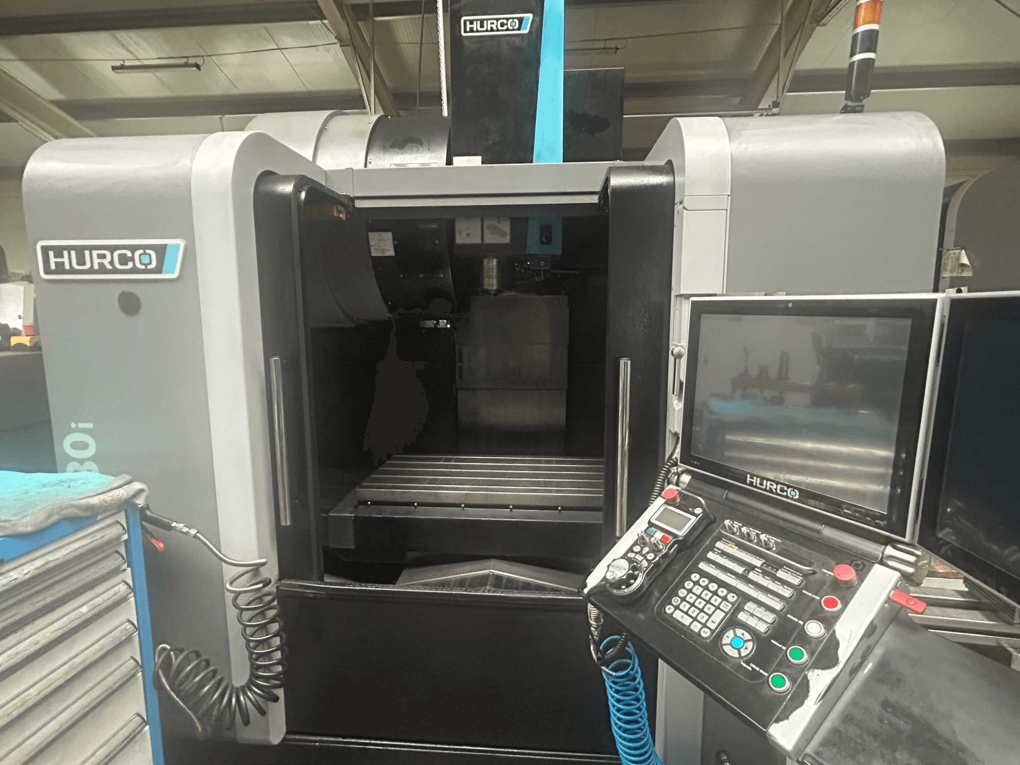 Hurco VM30i CNC gép előlapja, a gombokkal ellátott vezérlőpanel, a kijelző és a szerszámtároló terület.