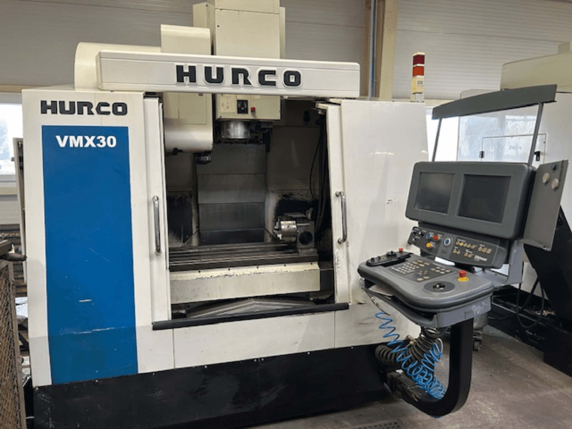 Hurco VMX30 CNC marógép egy műhelyben, elölnézetben; vezérlőpanel kettős képernyővel és kezelőgombokkal.