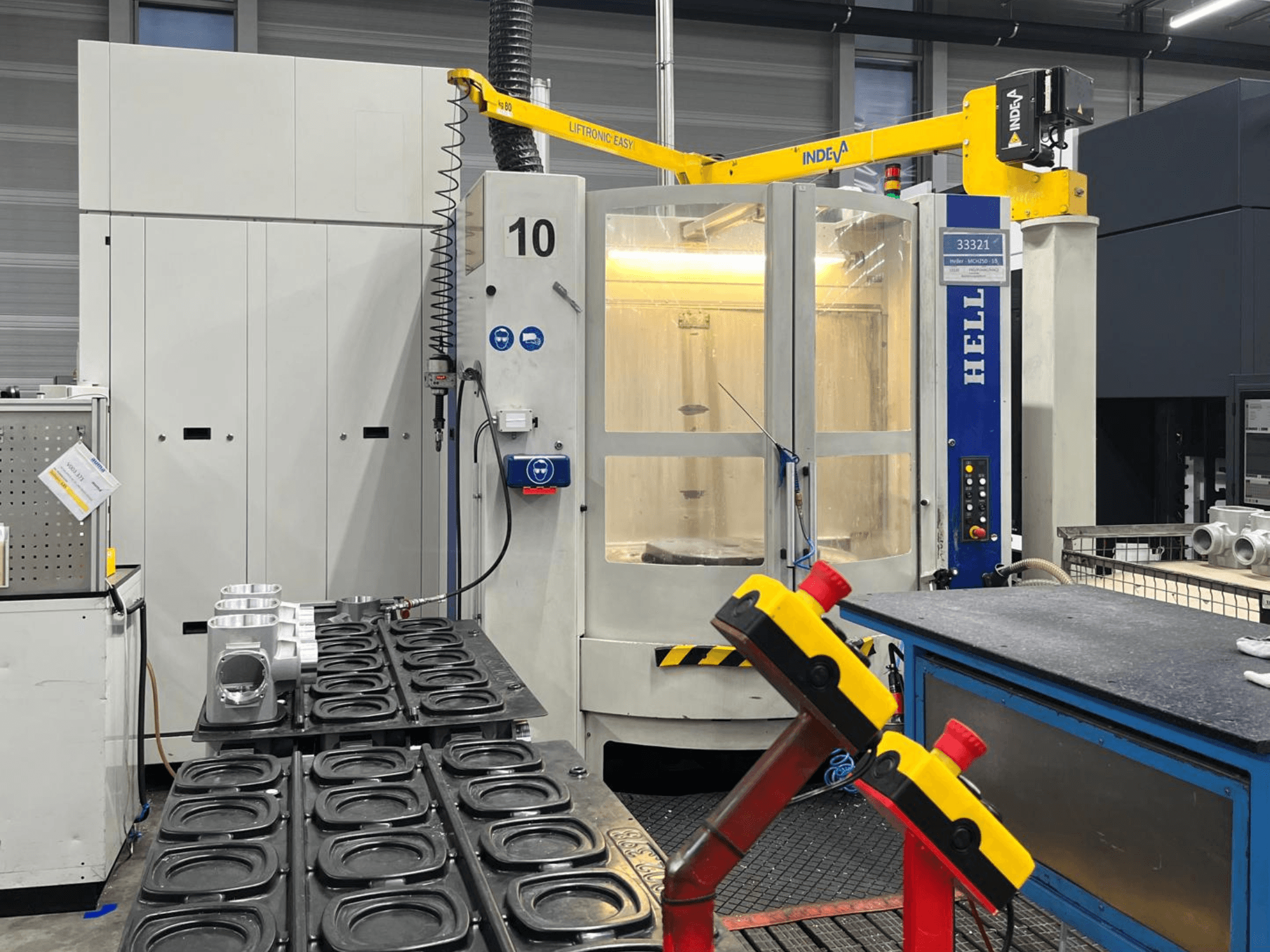 HELLER MCH 250 vízszintes megmunkálóközpont elölnézetben, alumínium alkatrészekkel és az oldalán látható vezérlőgombokkal.