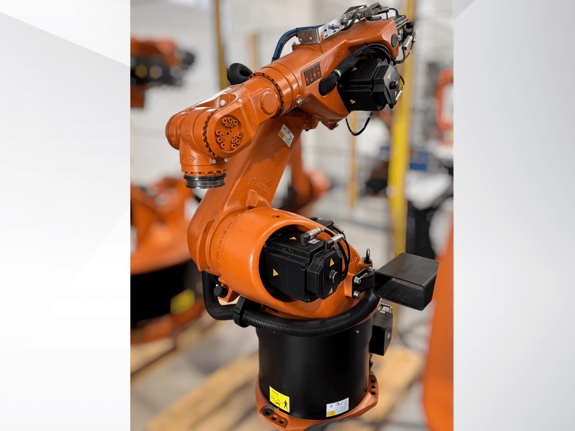 KUKA KR 60-3 robotkar narancssárga színben; oldalnézetben az alap, az ízületek és az automatizálási feladatokhoz szükséges vezérlőmodulok.
