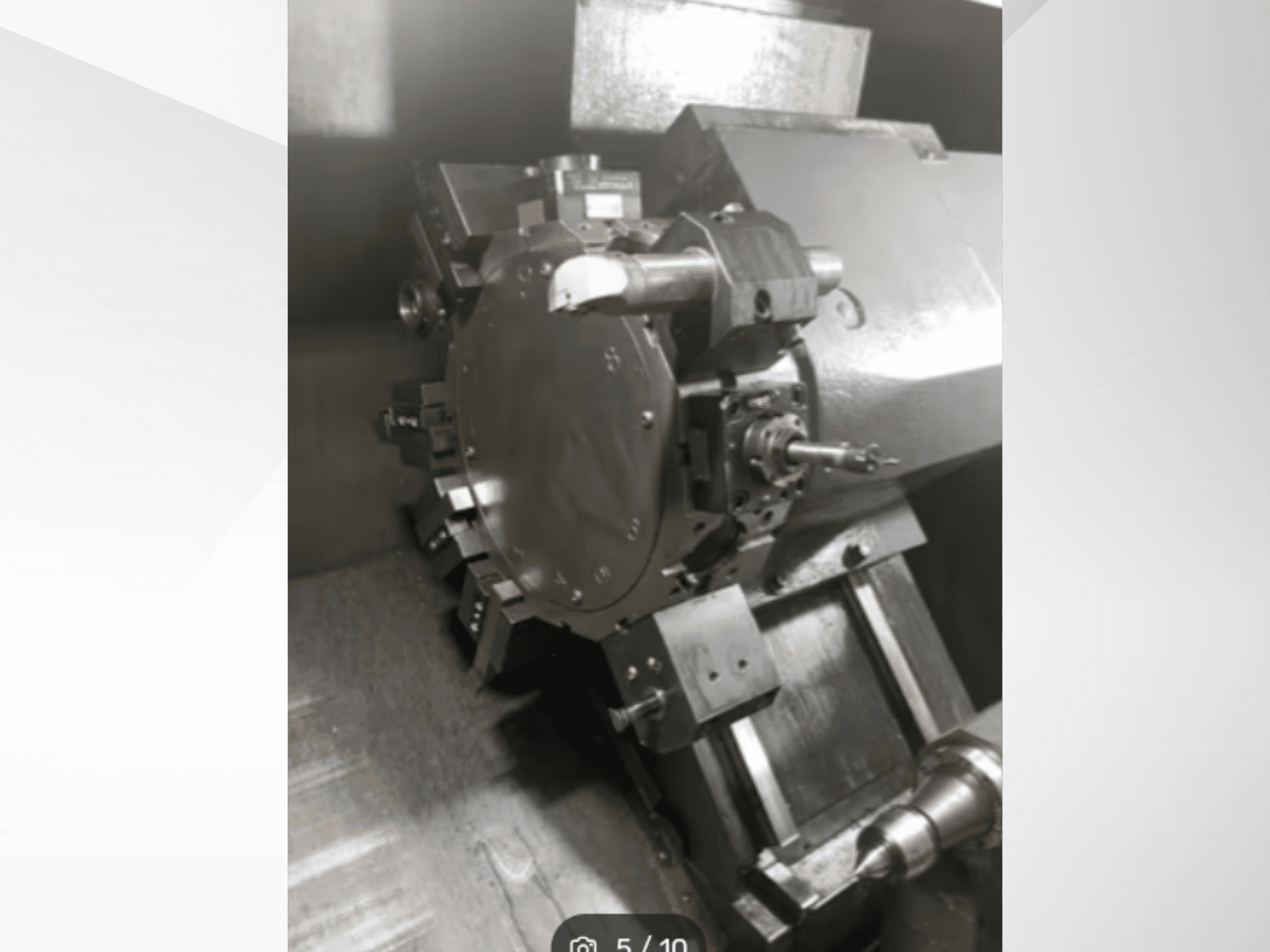 Közelkép egy precíziós gépalkatrészről, amelyen fogaskerekek és fém alkatrészek láthatók, szögletes perspektívából nézve. Márka nem látható.