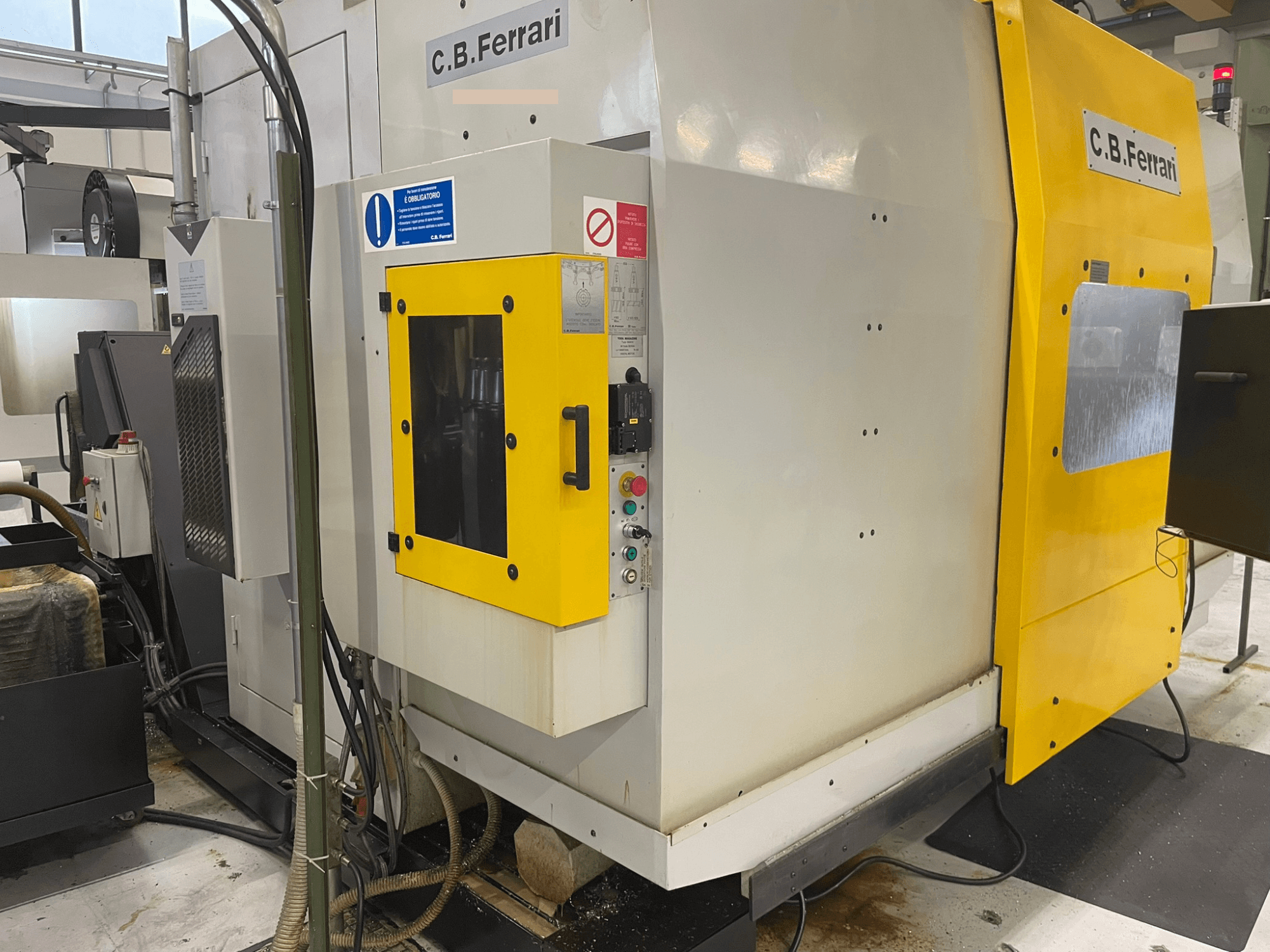 C.B. Ferrari ipari gép, előlnézet; sárga ajtó, vezérlőpanel és látható megmunkáló alkatrészek.