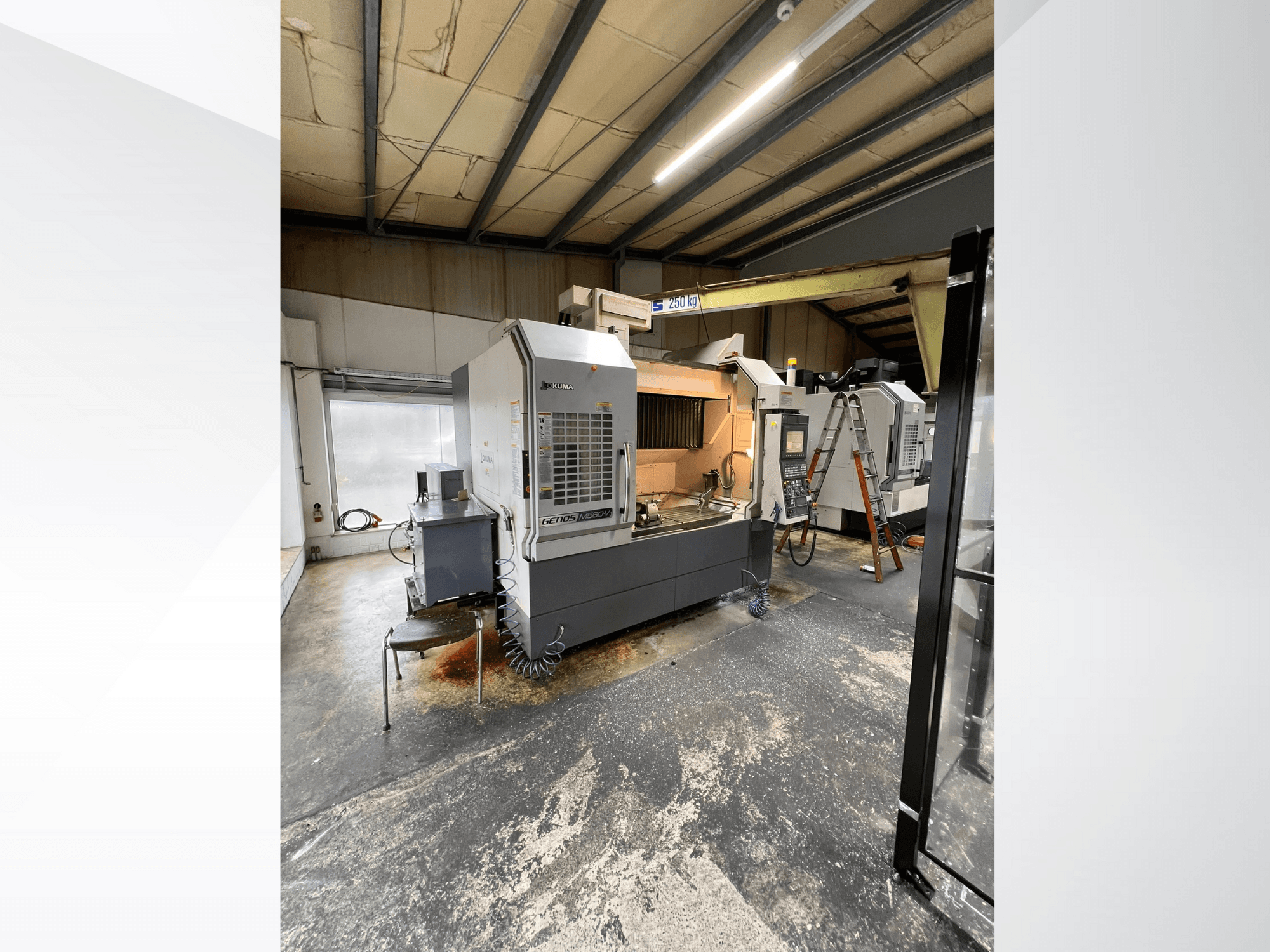 GRETOS 750 CNC gép egy műhelyben, elölnézetben, a vezérlőpanel és a szerszámokkal ellátott munkaterület látható, a háttérben látható létra.