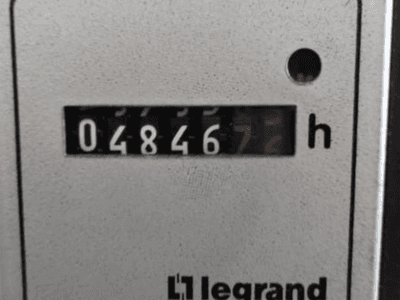 Legrand óraszámláló 048467.6, előlapi nézet, piros jelzőfénnyel és fekete számjegyekkel, világos, texturált háttéren.