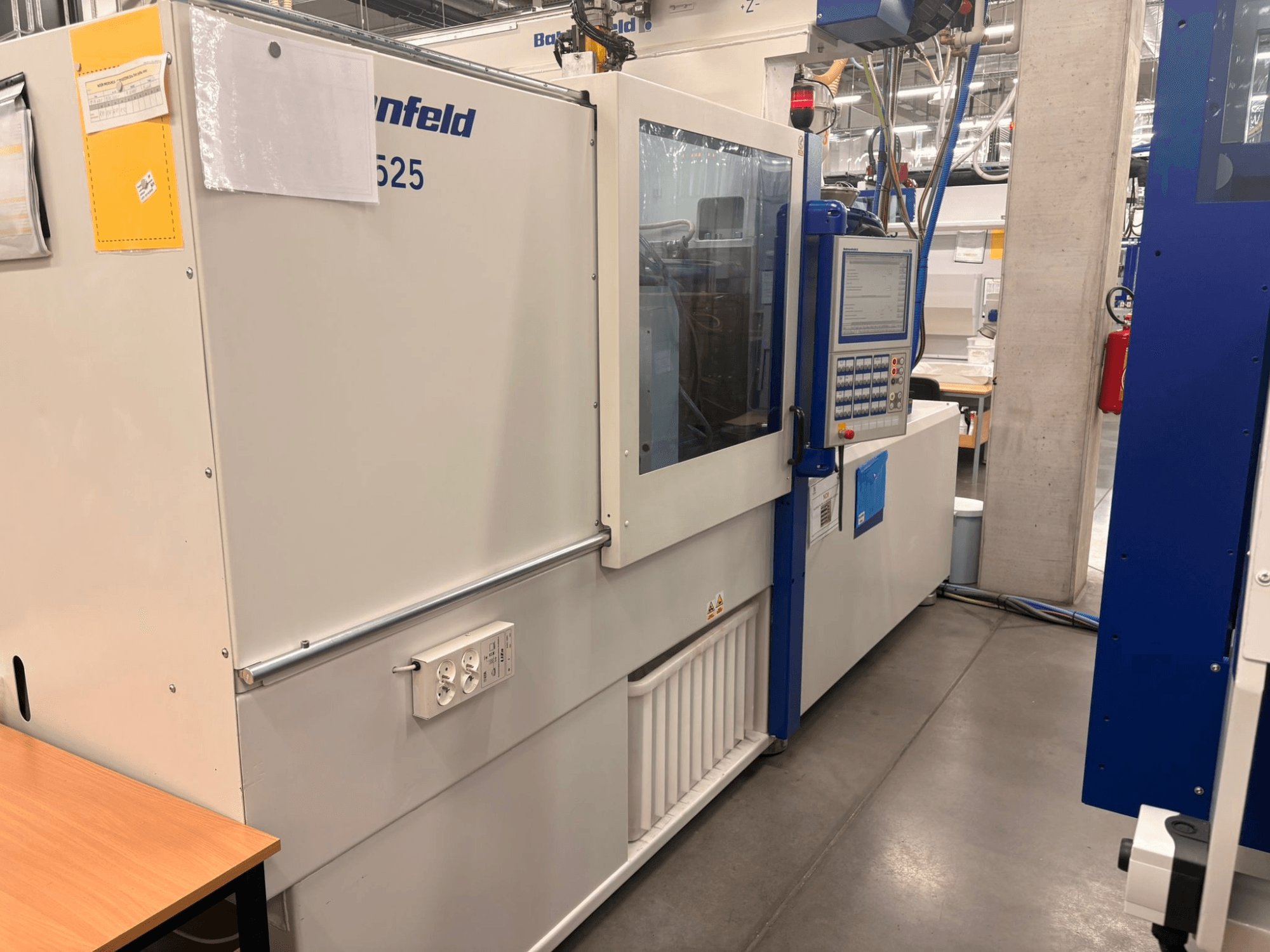 Arburg 620S modell, előlnézetben a vezérlőpanel és a tápcsatlakozók gyári környezetben.