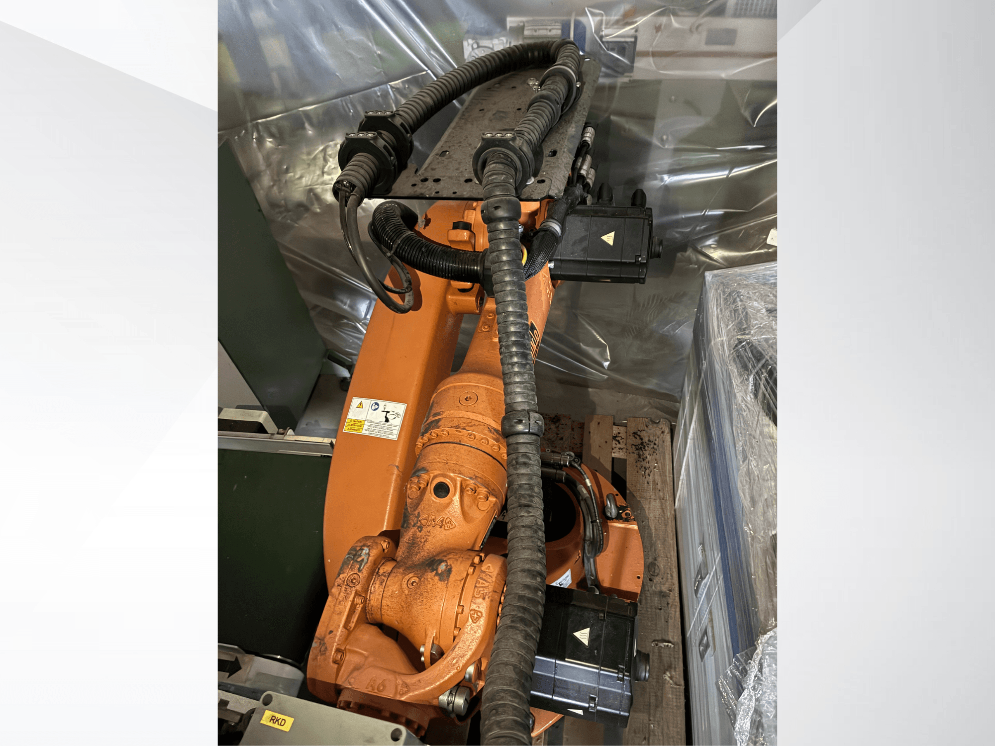 A KUKA KR16-2 robotkar narancssárga színben, felülnézetből, a csatlakozók és a védőcsövek láthatók.