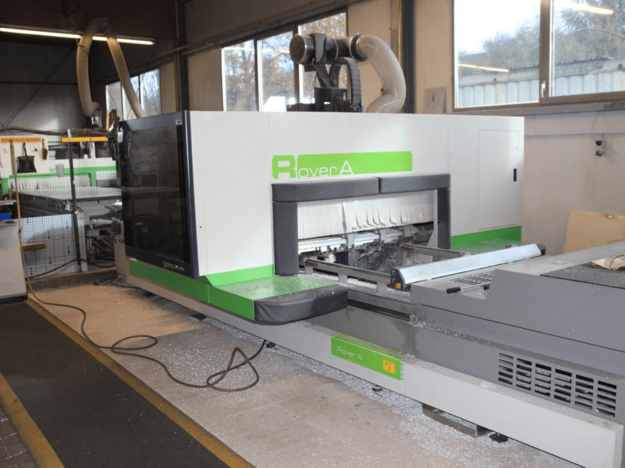 BIESSE Rover A 1232 CNC router, oldalnézet a vágási terület és a kezelőpanel ipari környezetben.